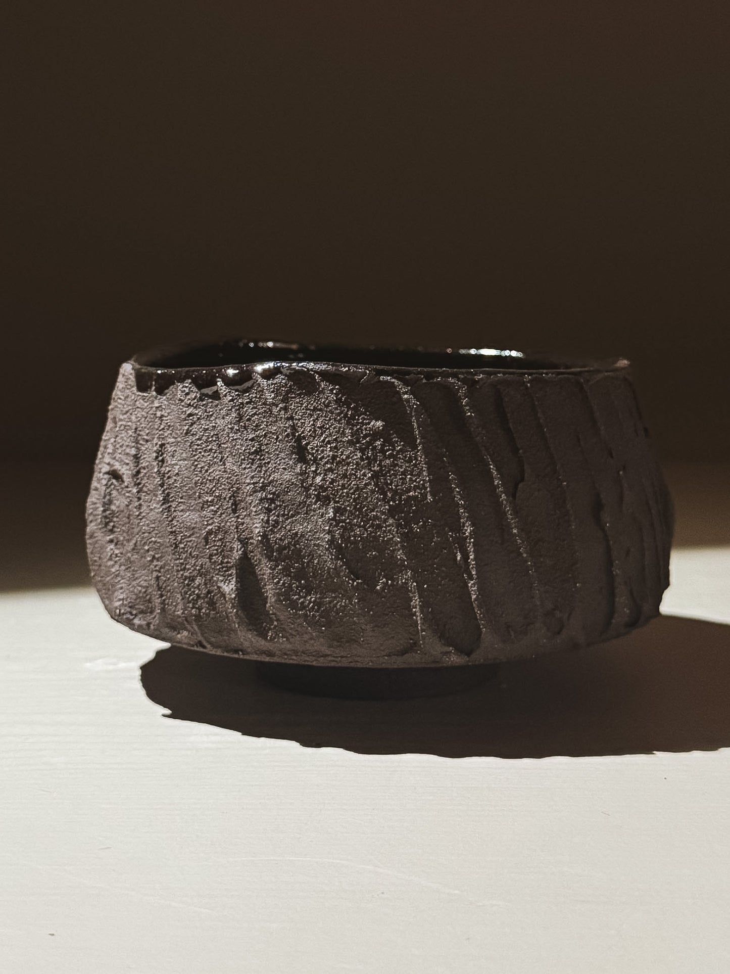 Kuro Matcha Bowl #03 featuring a textured dark brown exterior and glossy dark interior, showcasing earthy volcanic stone inspiration.