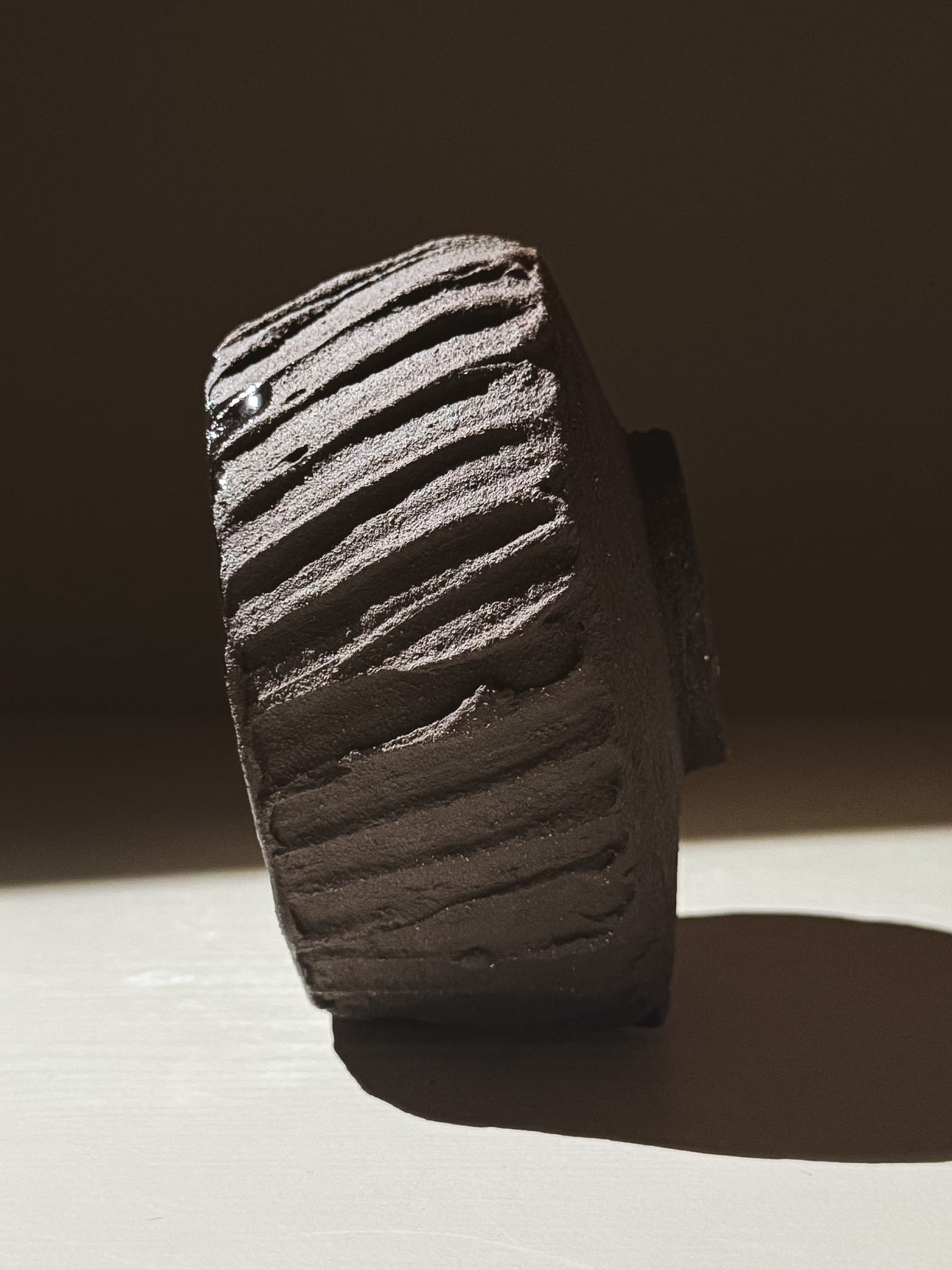 Kuro Matcha Bowl #03 showcasing textured dark brown slip and smooth glossy interior under soft lighting.