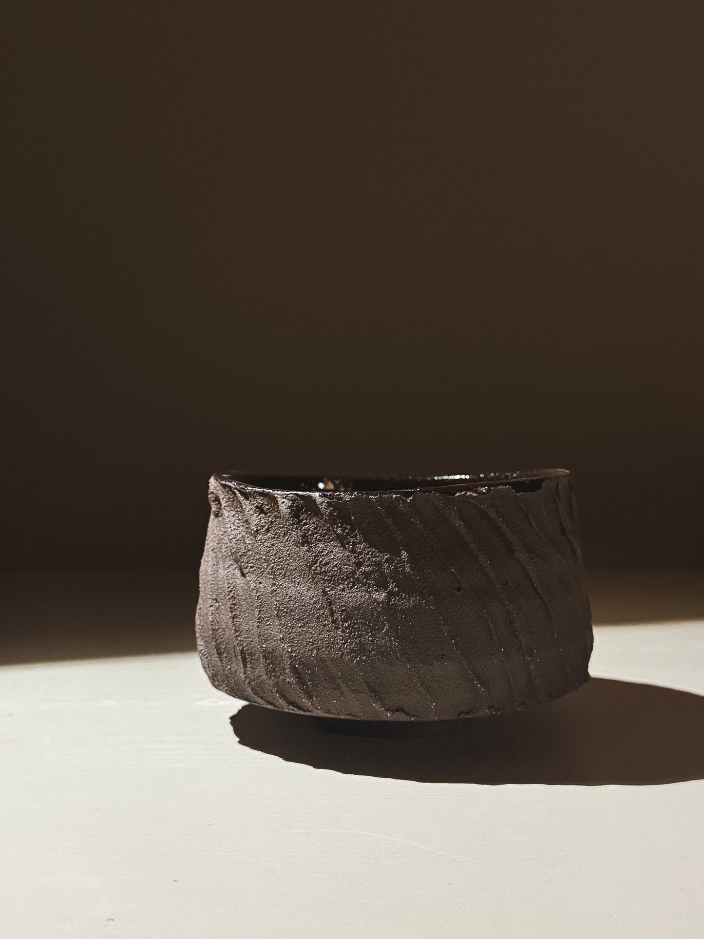 Kuro Matcha Bowl #04 showcasing earthy textures and a glossy dark glaze, inspired by volcanic stone.