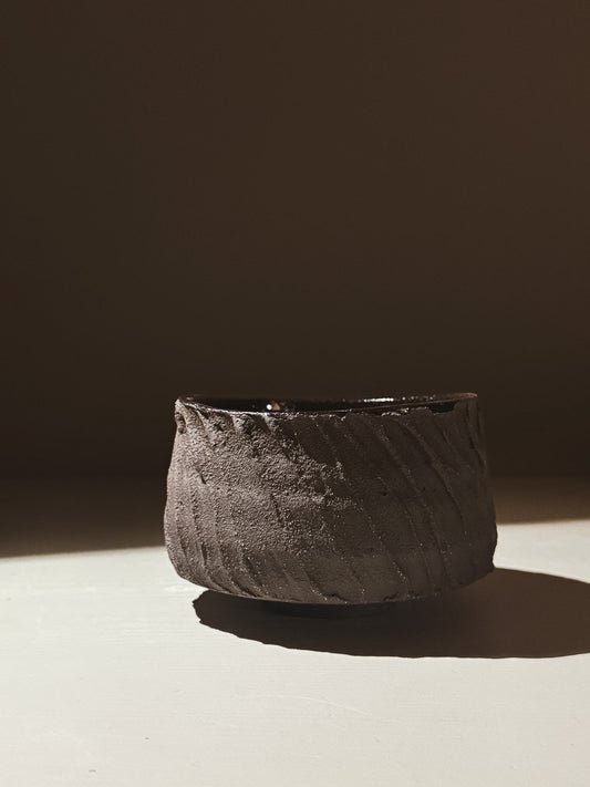 Kuro Matcha Bowl #04 showcasing earthy textures and a glossy dark glaze, inspired by volcanic stone.