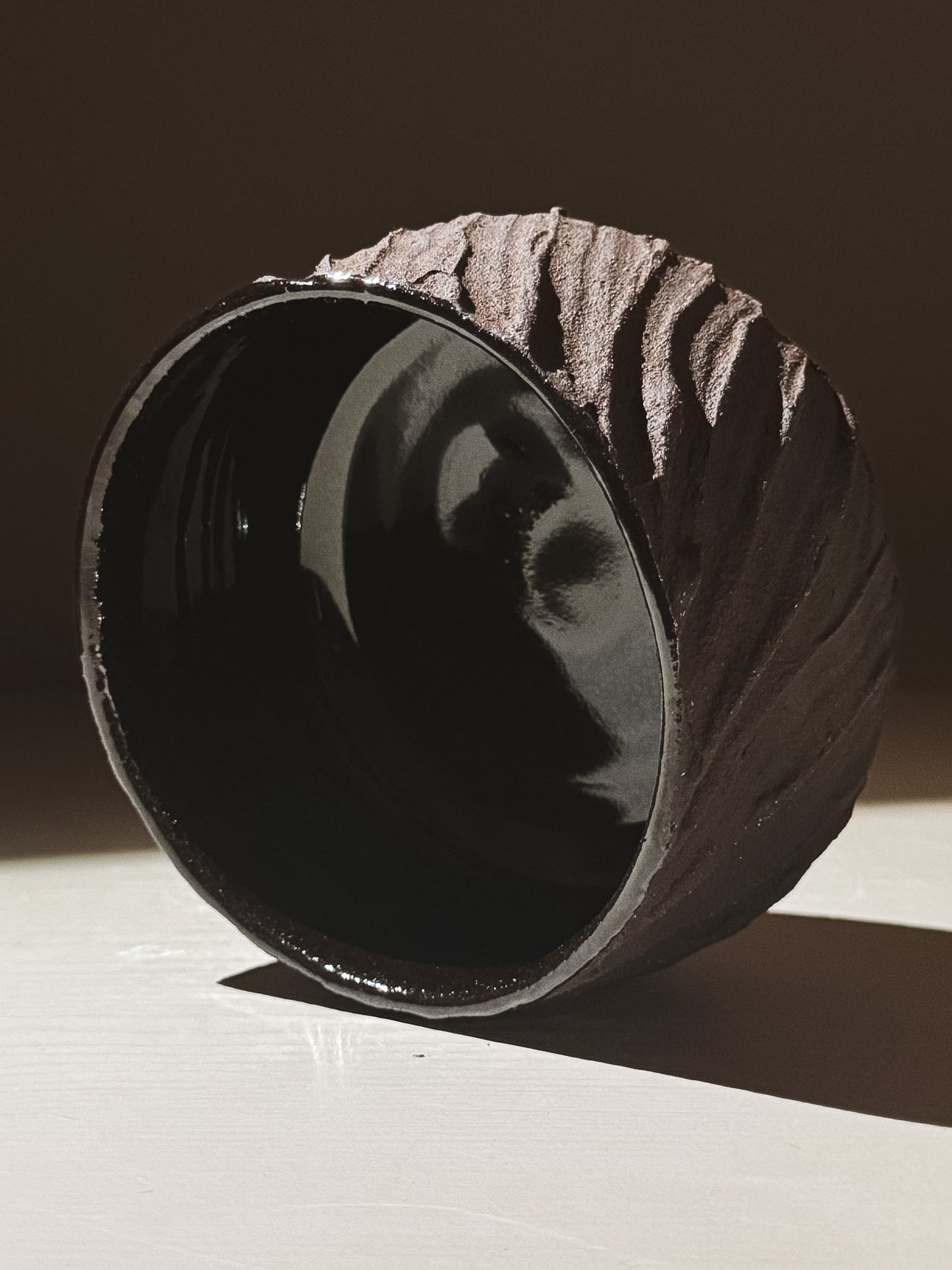 Kuro Matcha Bowl #04 showcasing textured dark brown exterior and glossy black interior, inspired by volcanic stone.