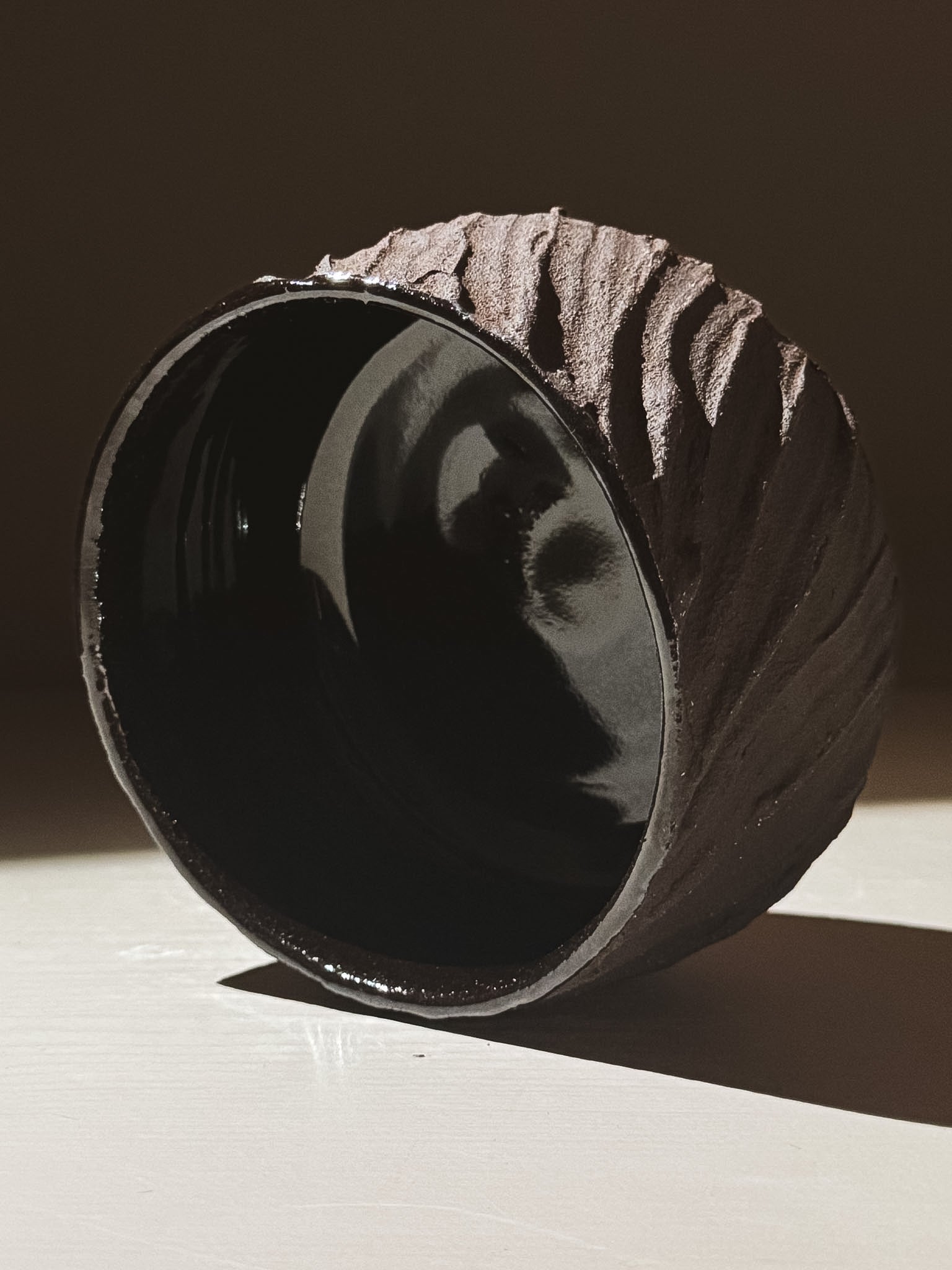 Kuro Matcha Bowl #04 showcasing textured dark brown exterior and glossy black interior, inspired by volcanic stone.