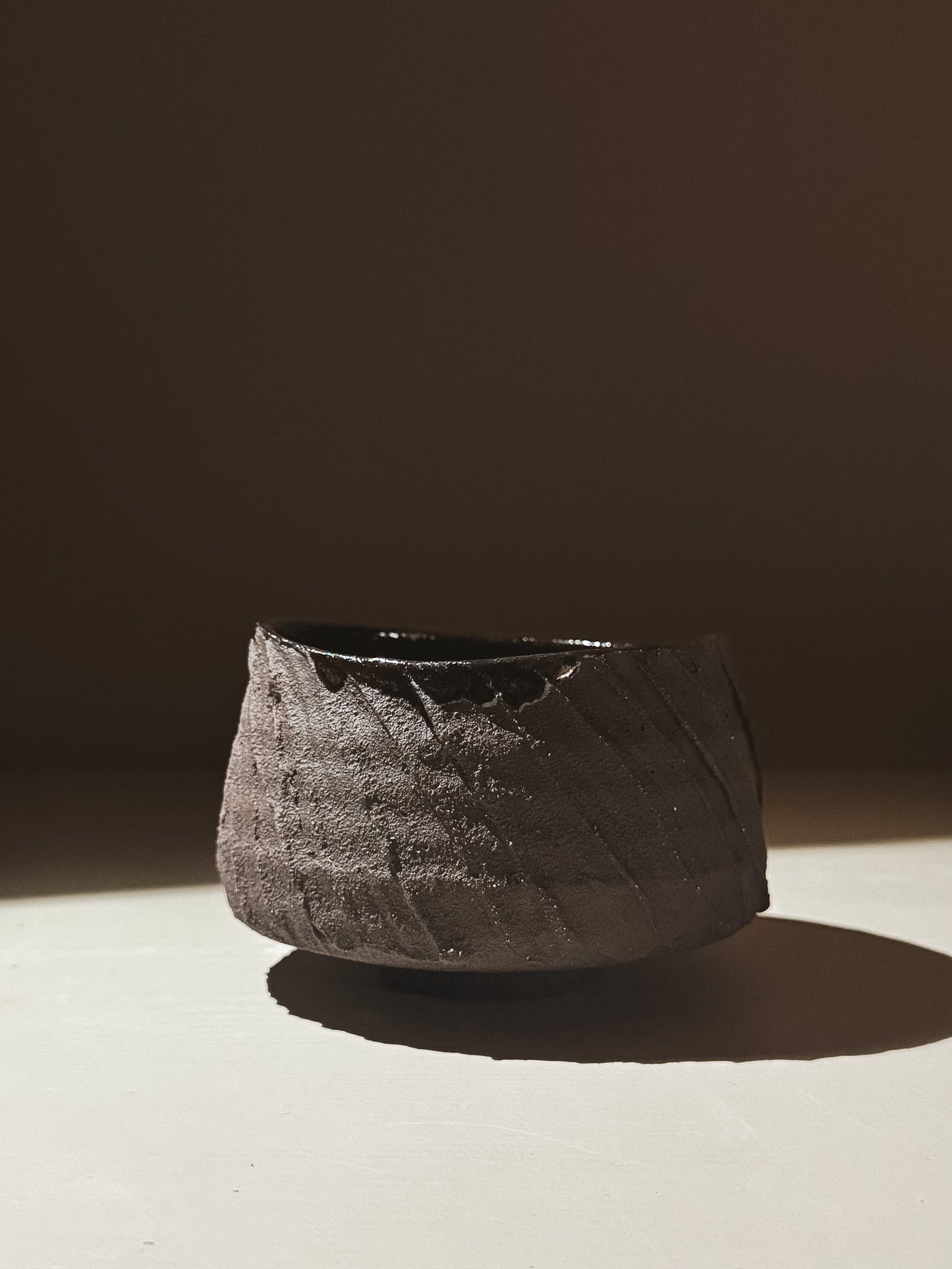 Kuro Matcha Bowl #05 with textured dark brown exterior and glossy black interior, inspired by volcanic stone.