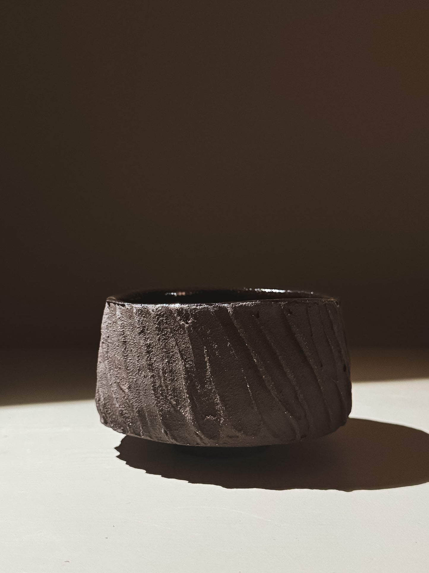 Kuro Matcha Bowl #06 with textured dark brown exterior and glossy interior in natural lighting.