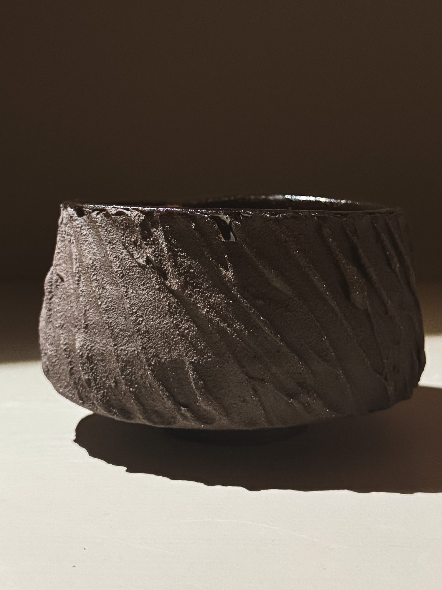 Kuro Matcha Bowl #06 featuring a heavily textured dark brown exterior and glossy interior, inspired by volcanic stone.