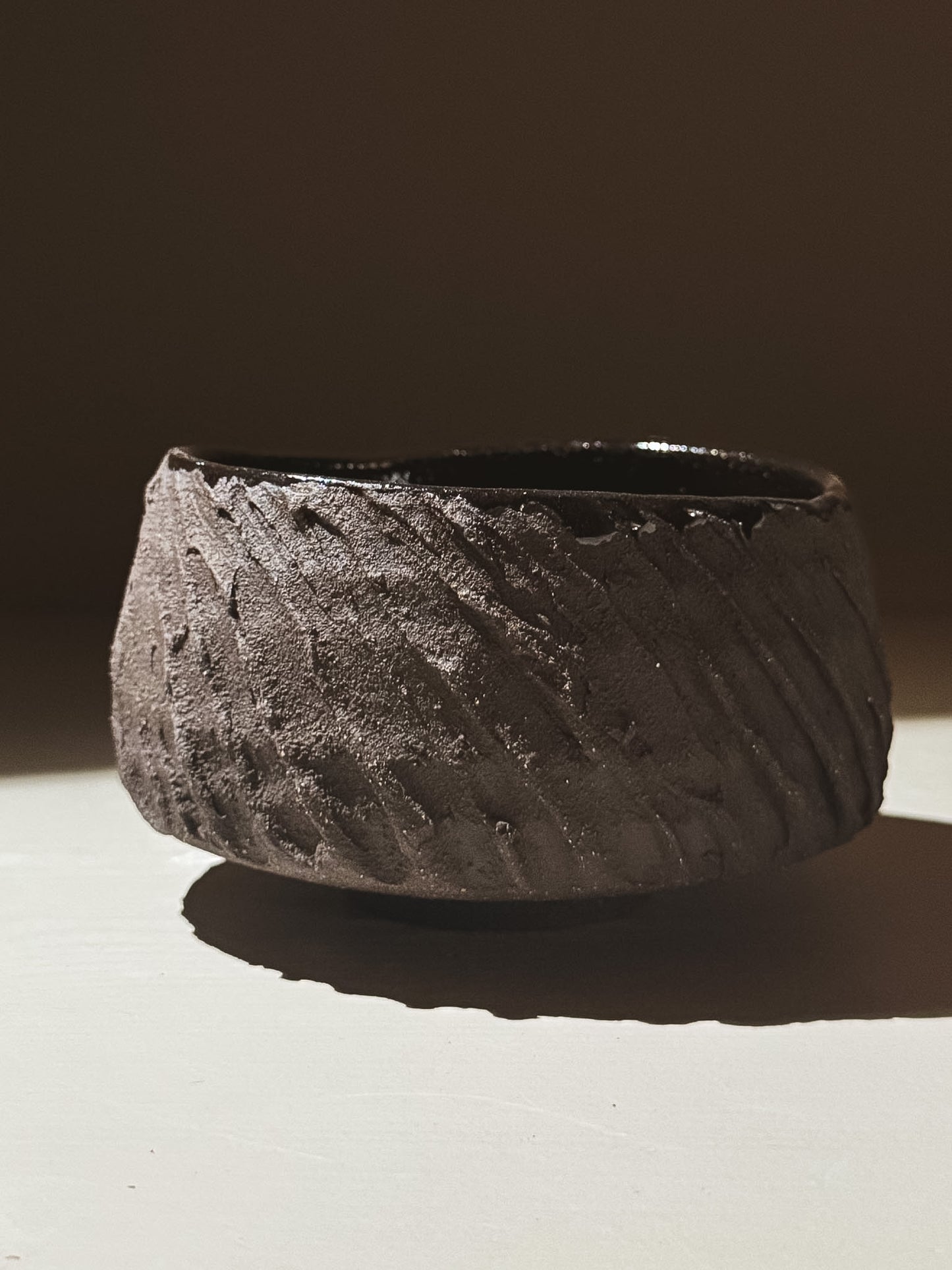 Kuro Matcha Bowl #08 with textured dark brown exterior and glossy dark interior, showcasing earthy volcanic-inspired design.