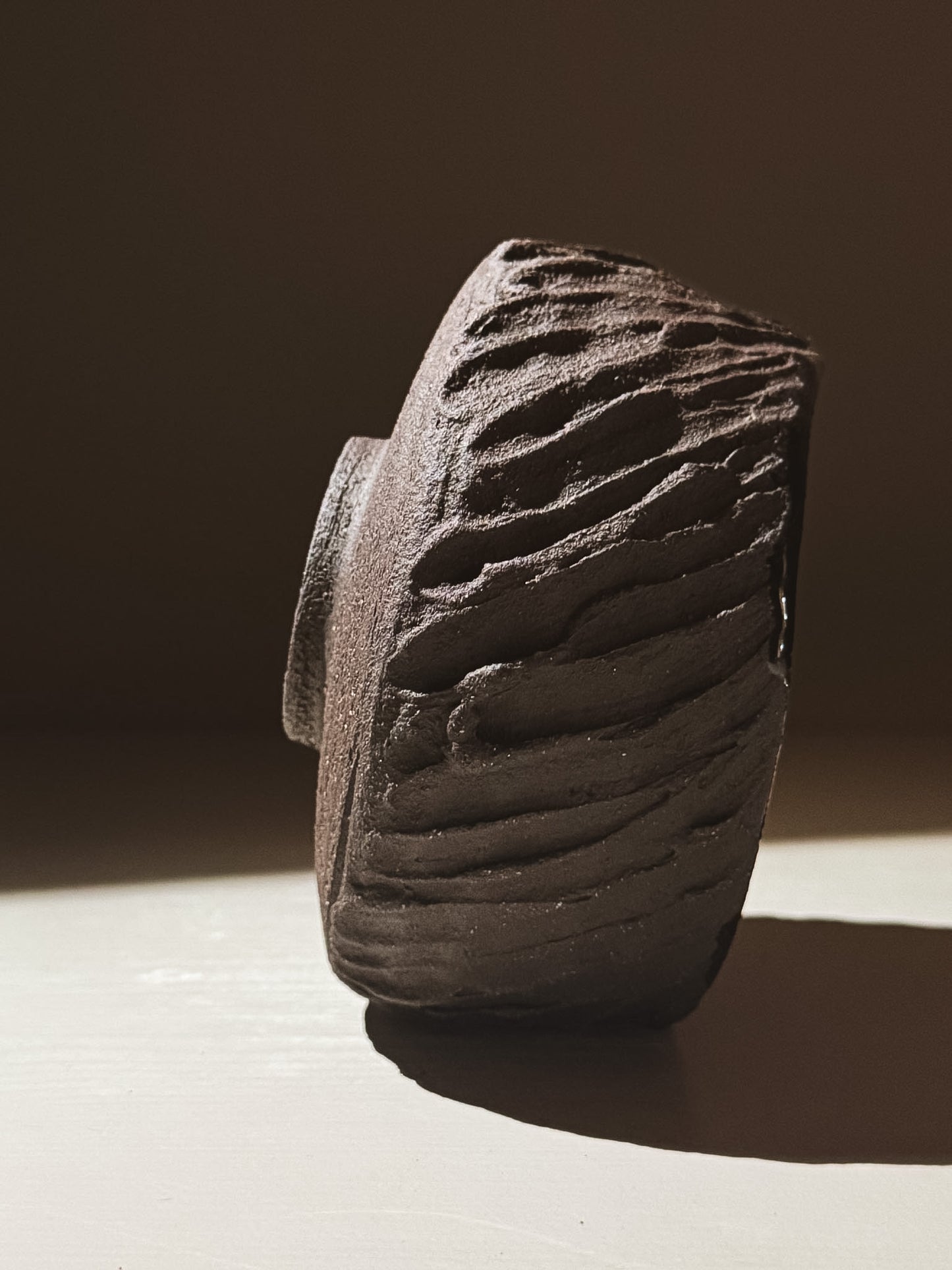 Kuro Matcha Bowl #08 featuring a textured dark brown exterior and glossy interior, inspired by volcanic stone.