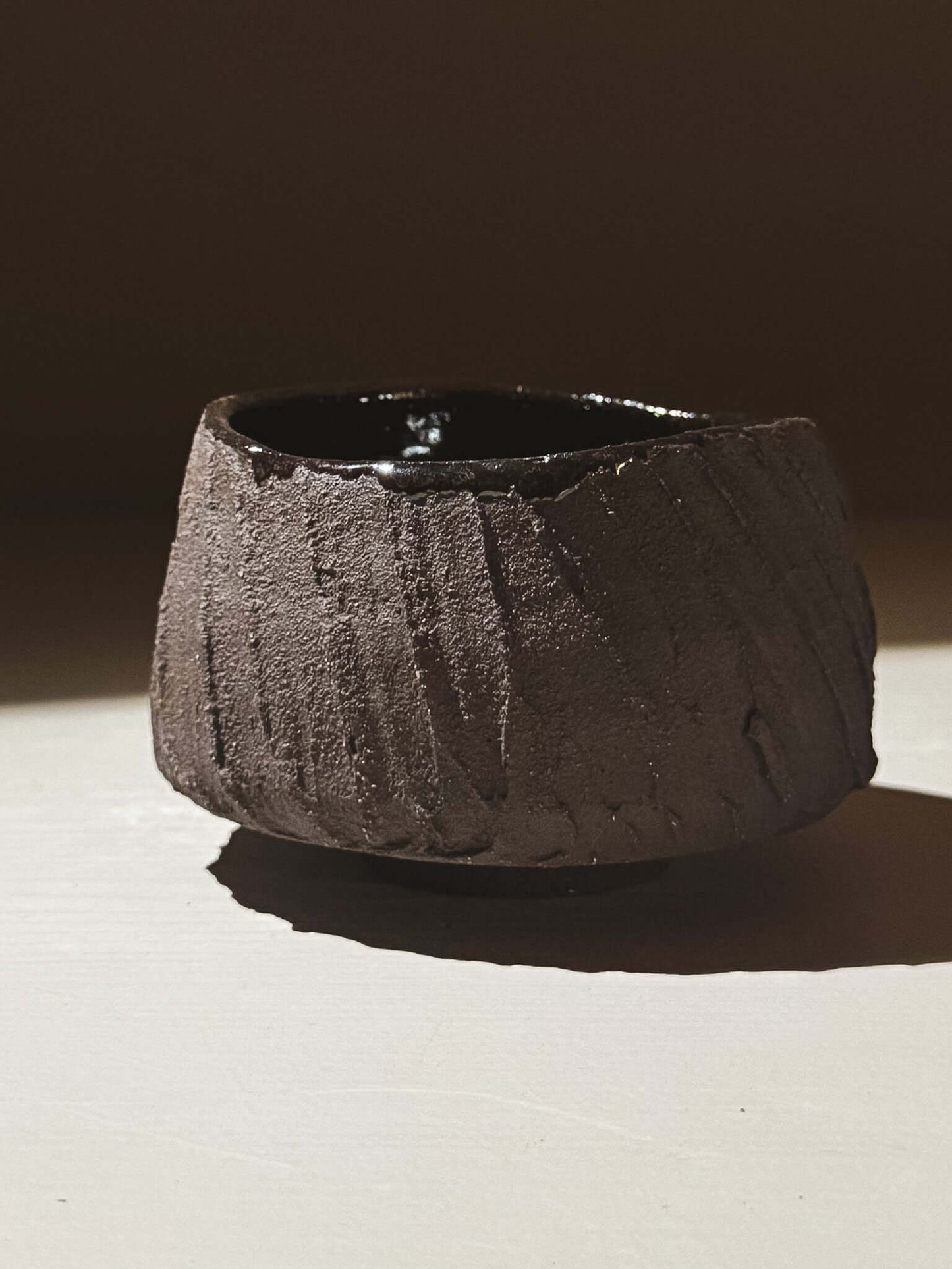 Yunomi Cup - Kuro #01 showcasing textured dark brown clay and glossy black interior, highlighting earthy volcanic inspiration.