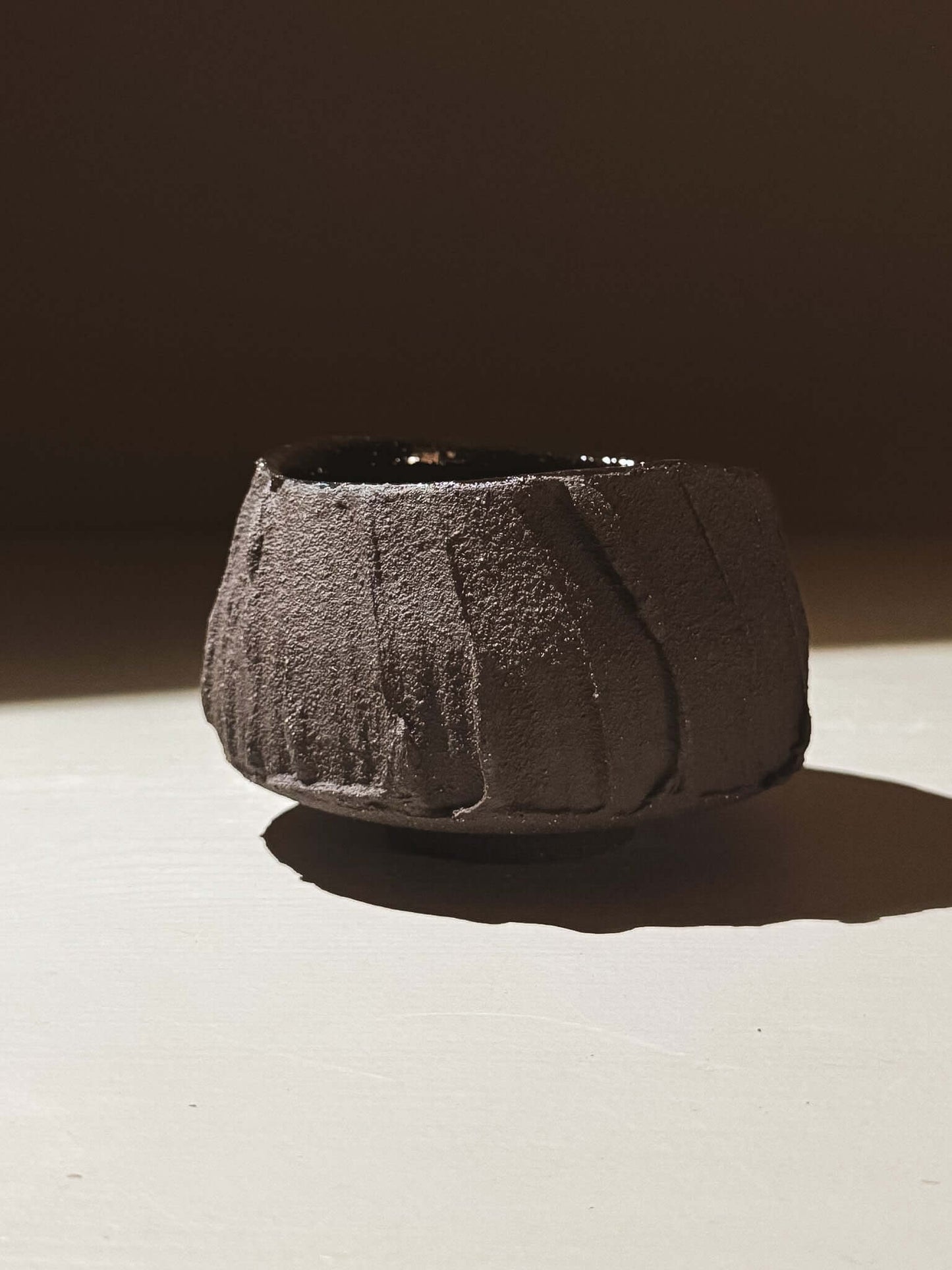 Yunomi Cup - Kuro #03 featuring textured dark brown clay exterior and glossy interior, inspired by volcanic stone.