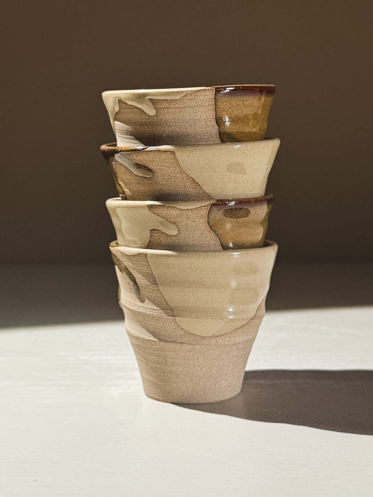 Espresso Cup - Inyo #01 stack of handmade ceramic cups featuring glossy tenmoku glaze and warm toffee tones.