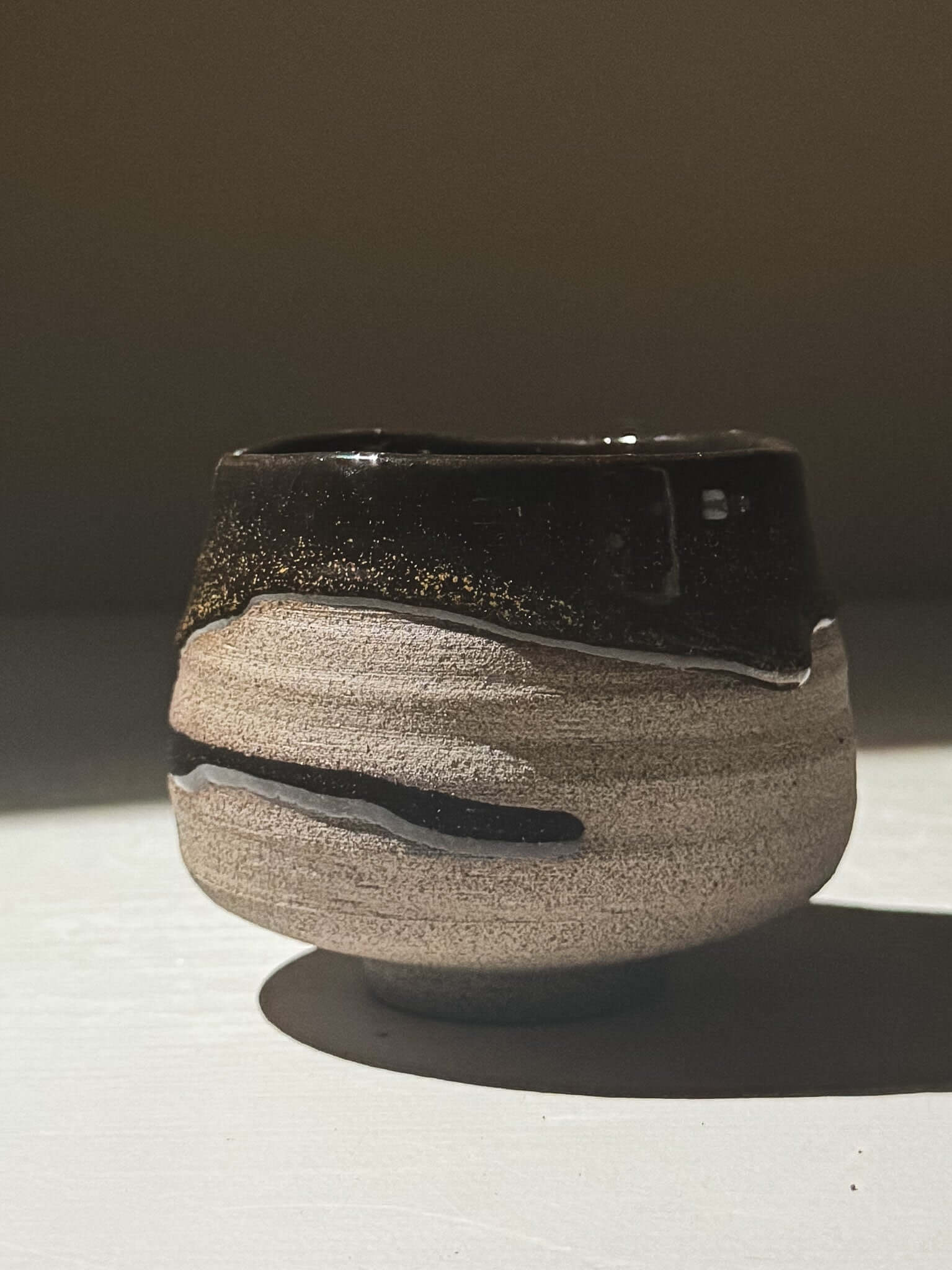 Yunomi Cup - Kuro Ash #03 showcasing glossy black glaze with golden speckles and natural texture.