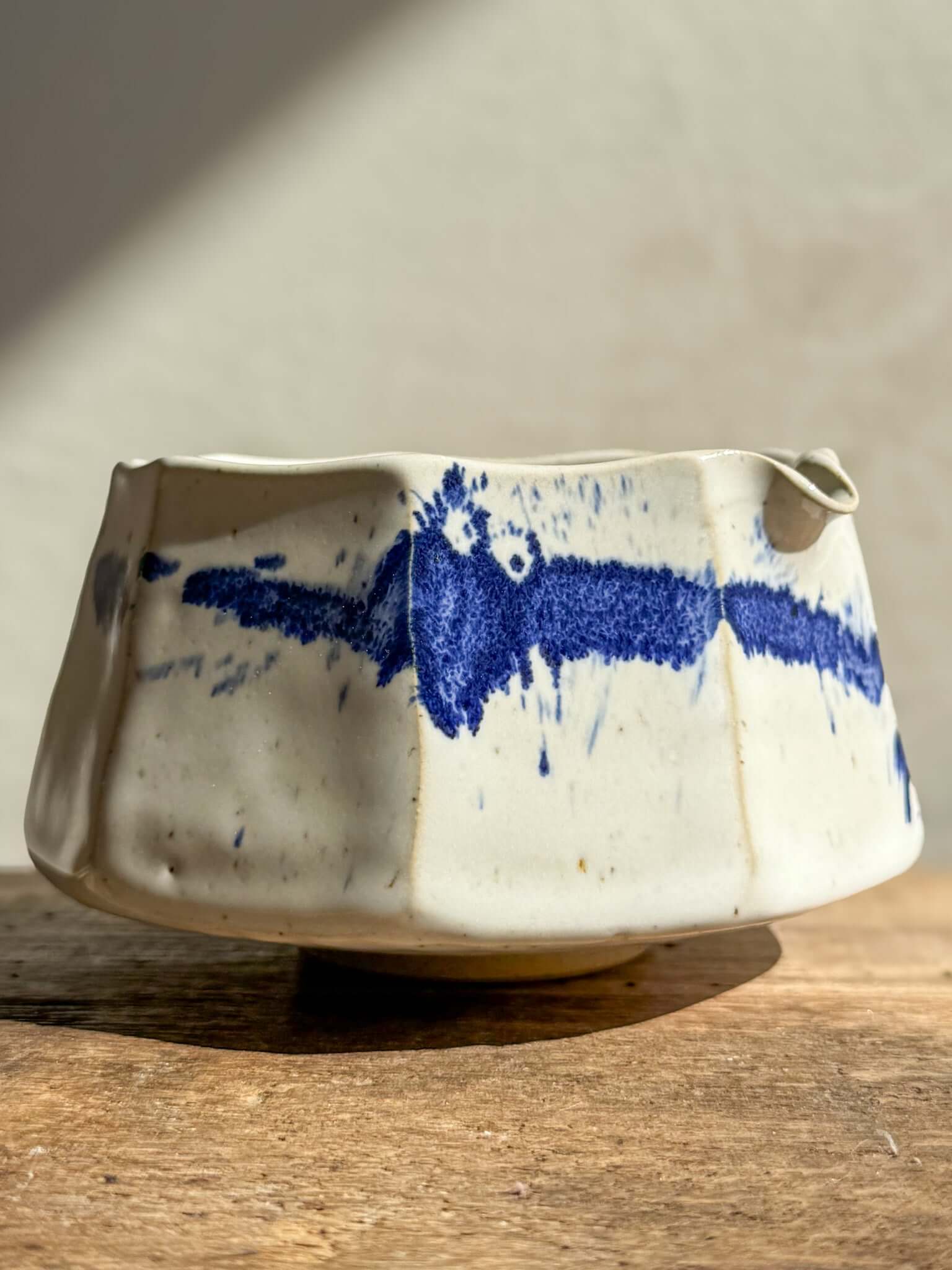 Faceted Matcha Bowl with Spout in Cobalt Blue and Glossy White Glaze, showing hand-splashed blue accents and textured design.