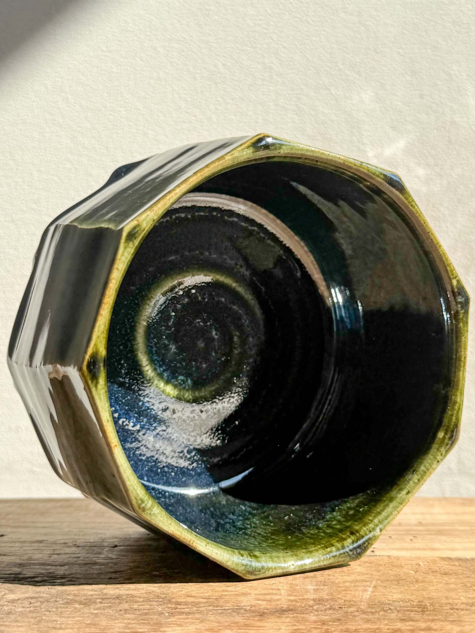 Faceted matcha bowl from Hinoki Series with deep green glaze and hand-carved facets, highlighting rich textures and moody pools.