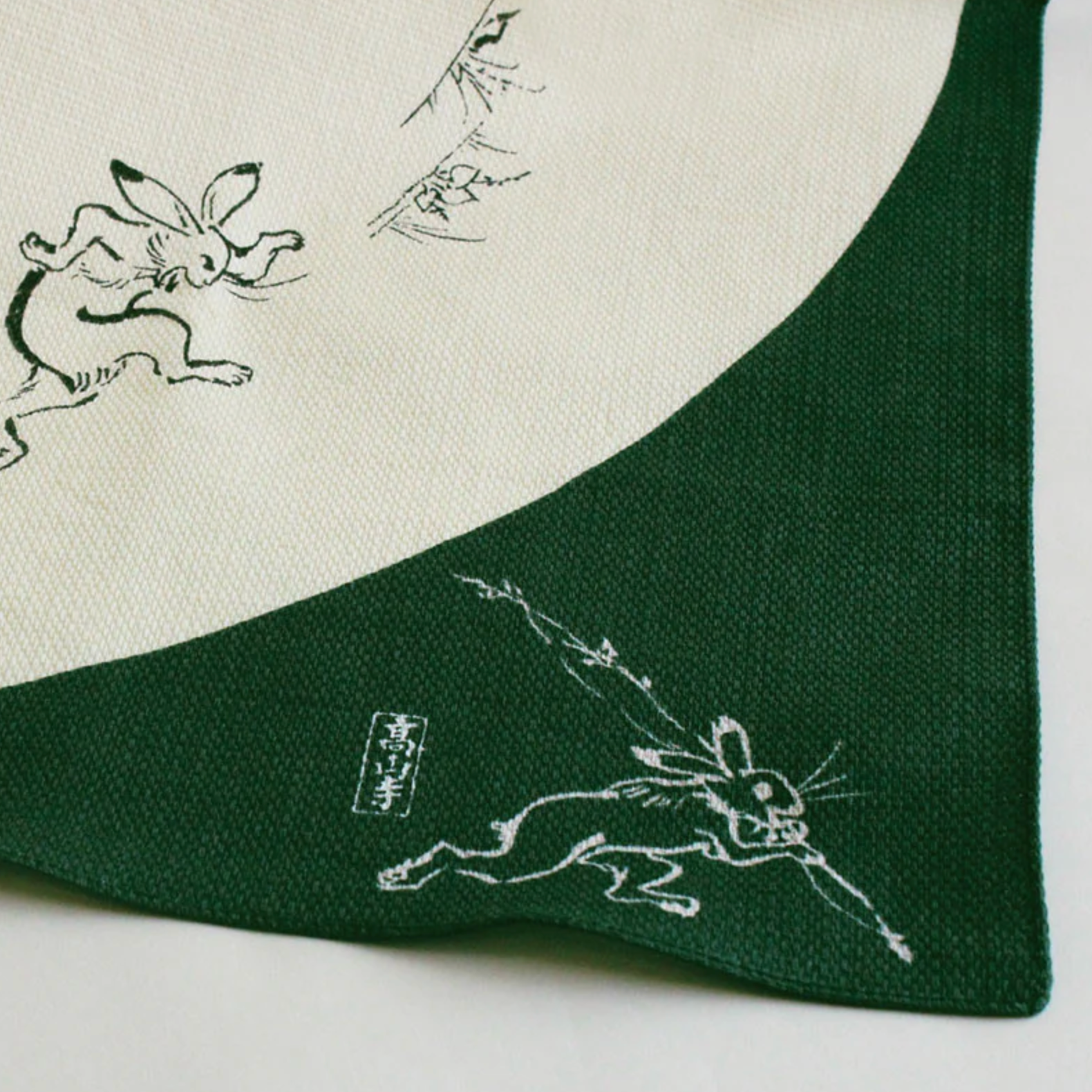Corner detail of green medium furoshiki cloth with animal illustration inspired by Choju Jinbutsu Giga.