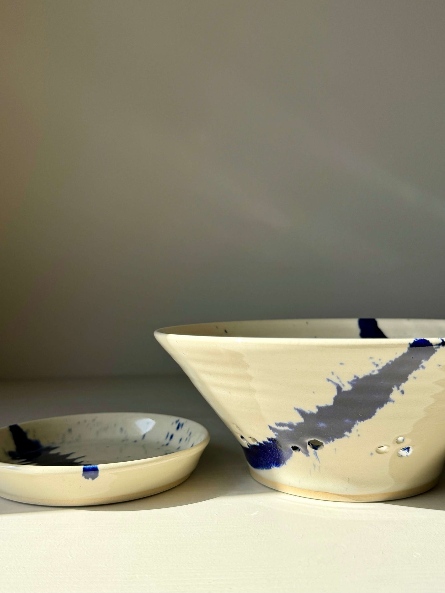 Sculptural berry bowl with cobalt splashes from the Gosu Series #01, featuring a matching drip plate, perfect for rinsing fresh fruit.
