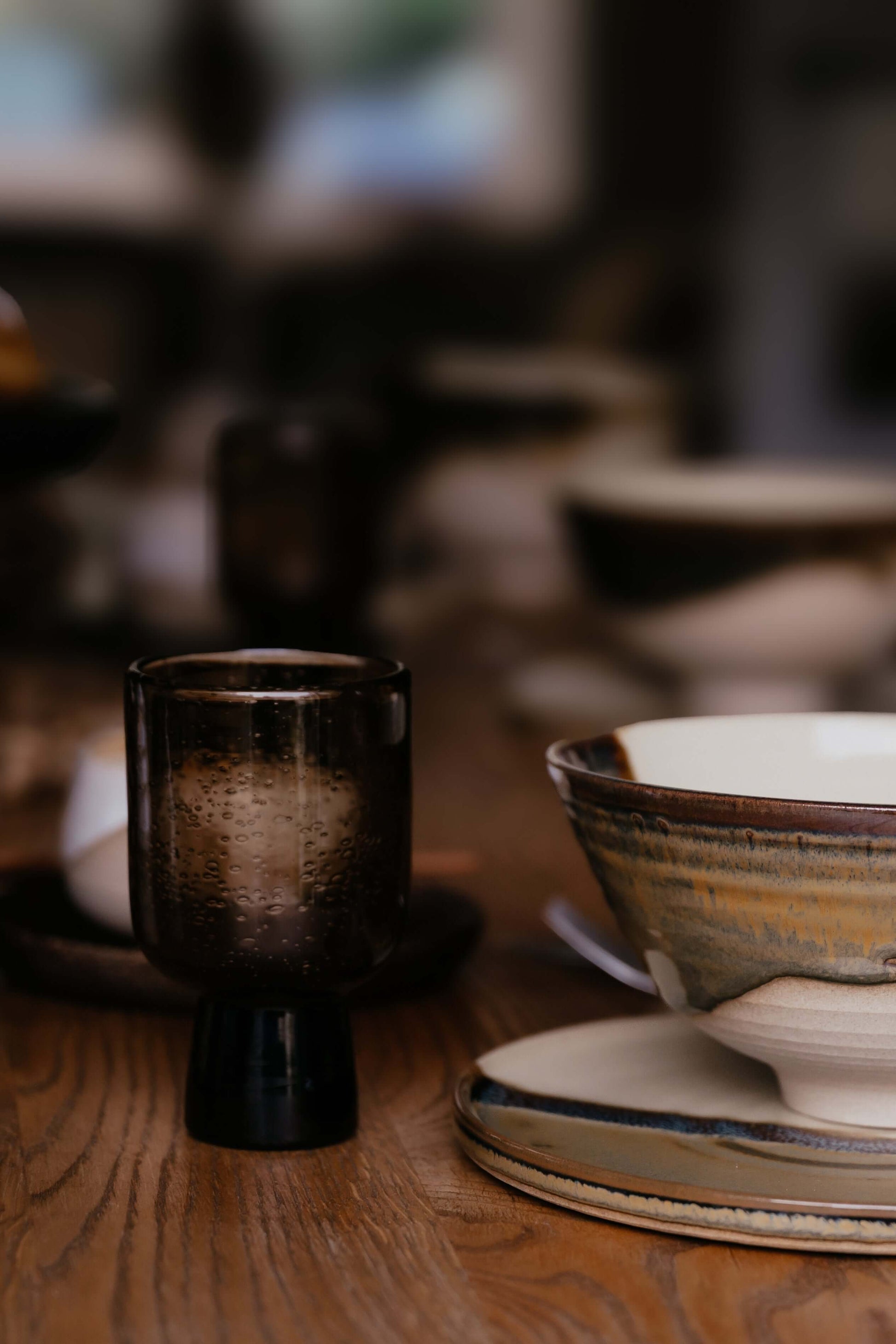 Brown Pedestal Glass – Natural Bubbled Glass with handmade ceramics on a wooden table