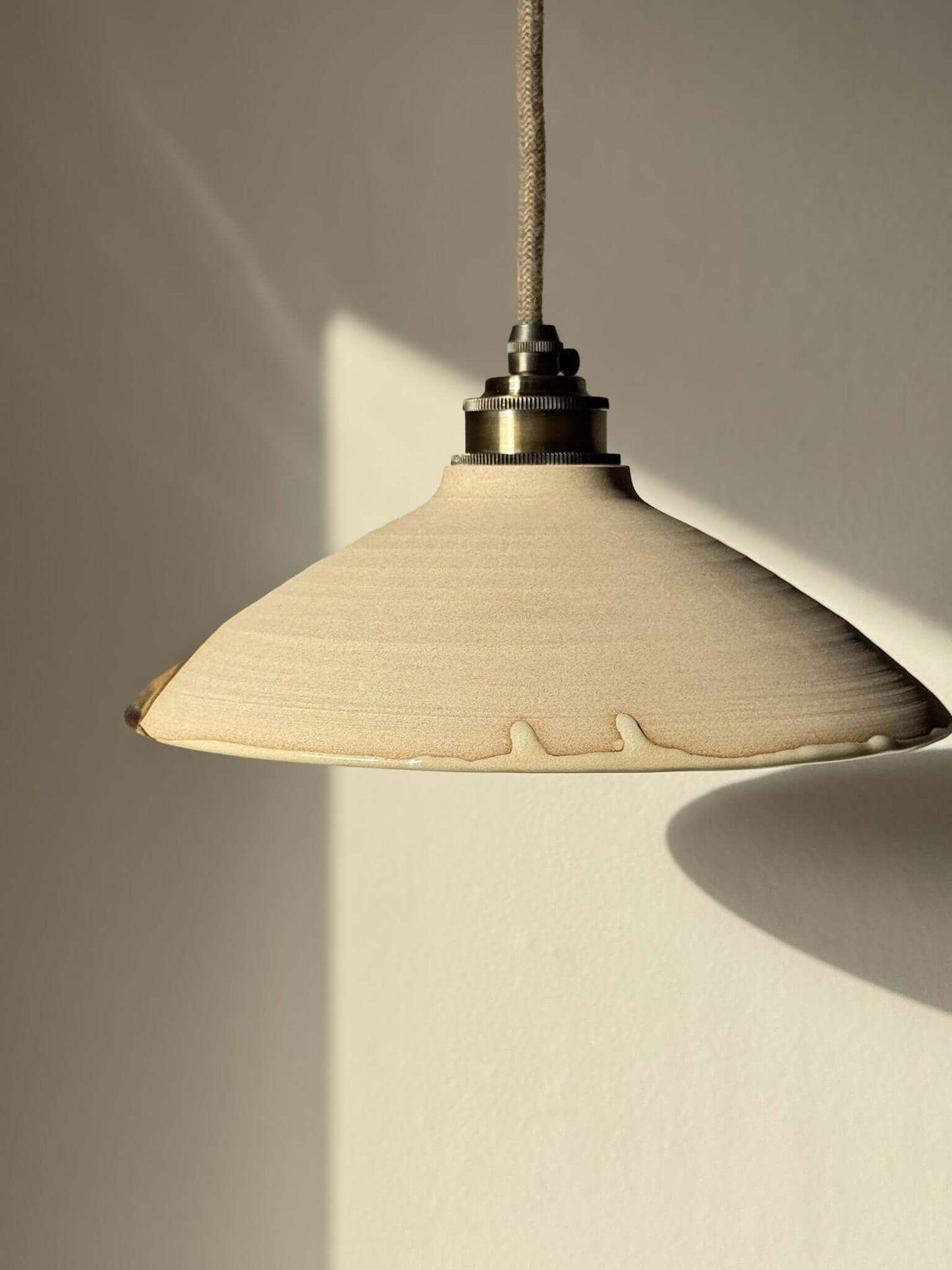 Ceramic Lamp Shade – Inyo #02, handmade ceramic with raw clay texture and glossy glaze highlighting bronze and amber tones.