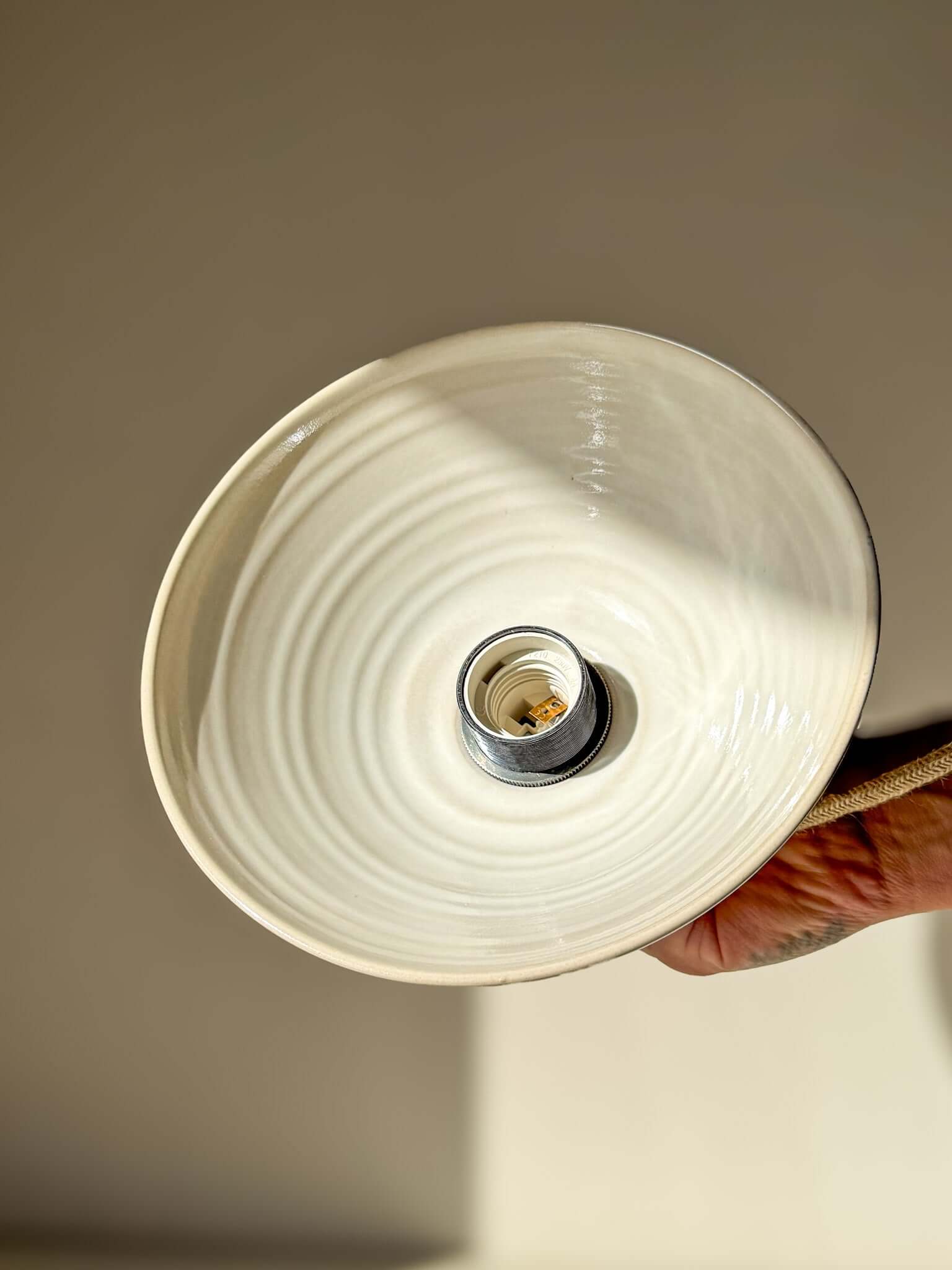 Ceramic Lamp Shade – Yuki #01 - Custom Order held from below, showcasing its soft snowy tones and glossy finish.
