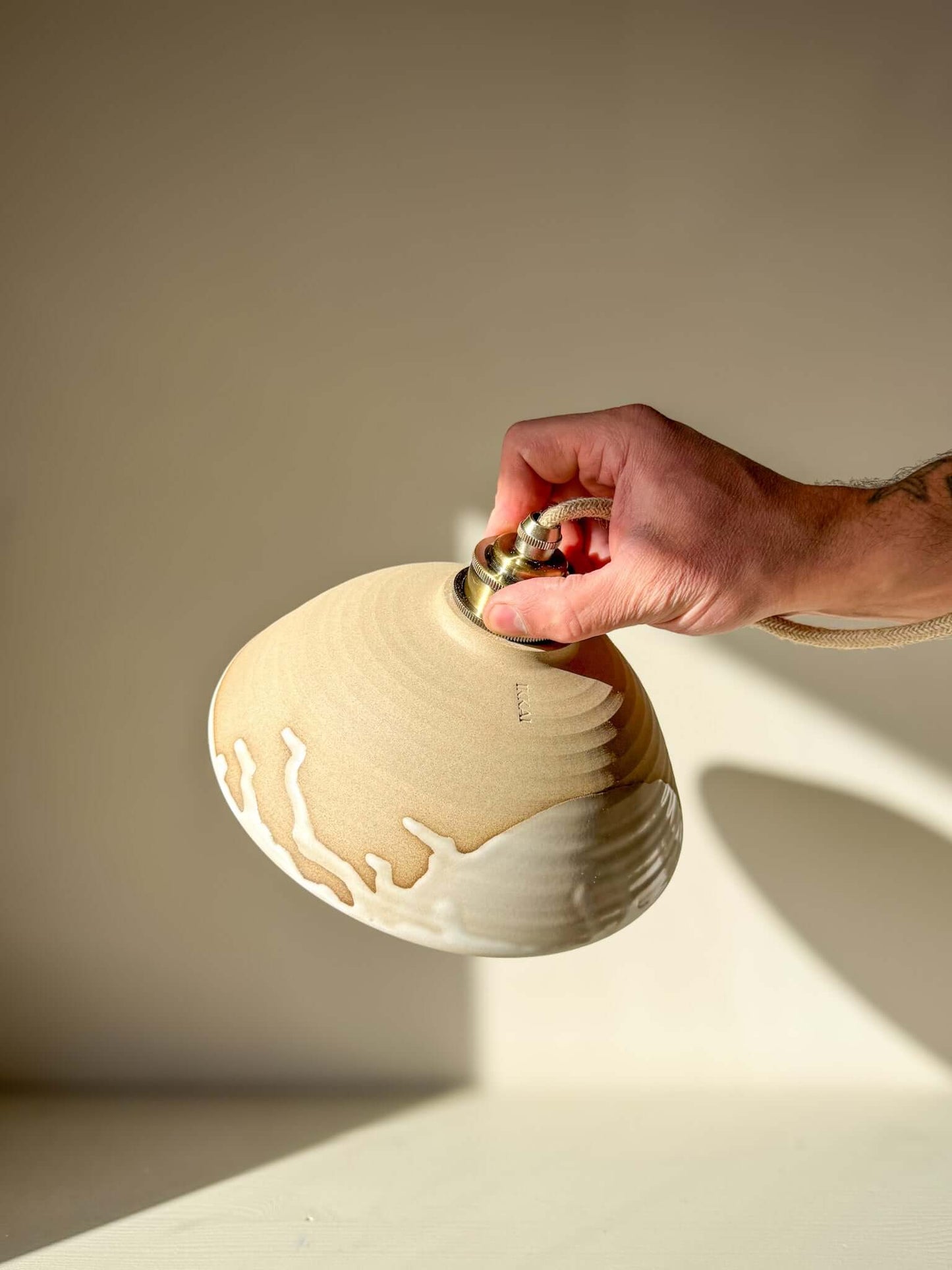 Hand holding a Ceramic Lamp Shade – Yuki #01 - Custom Order, showcasing its warm tones and glossy glaze.