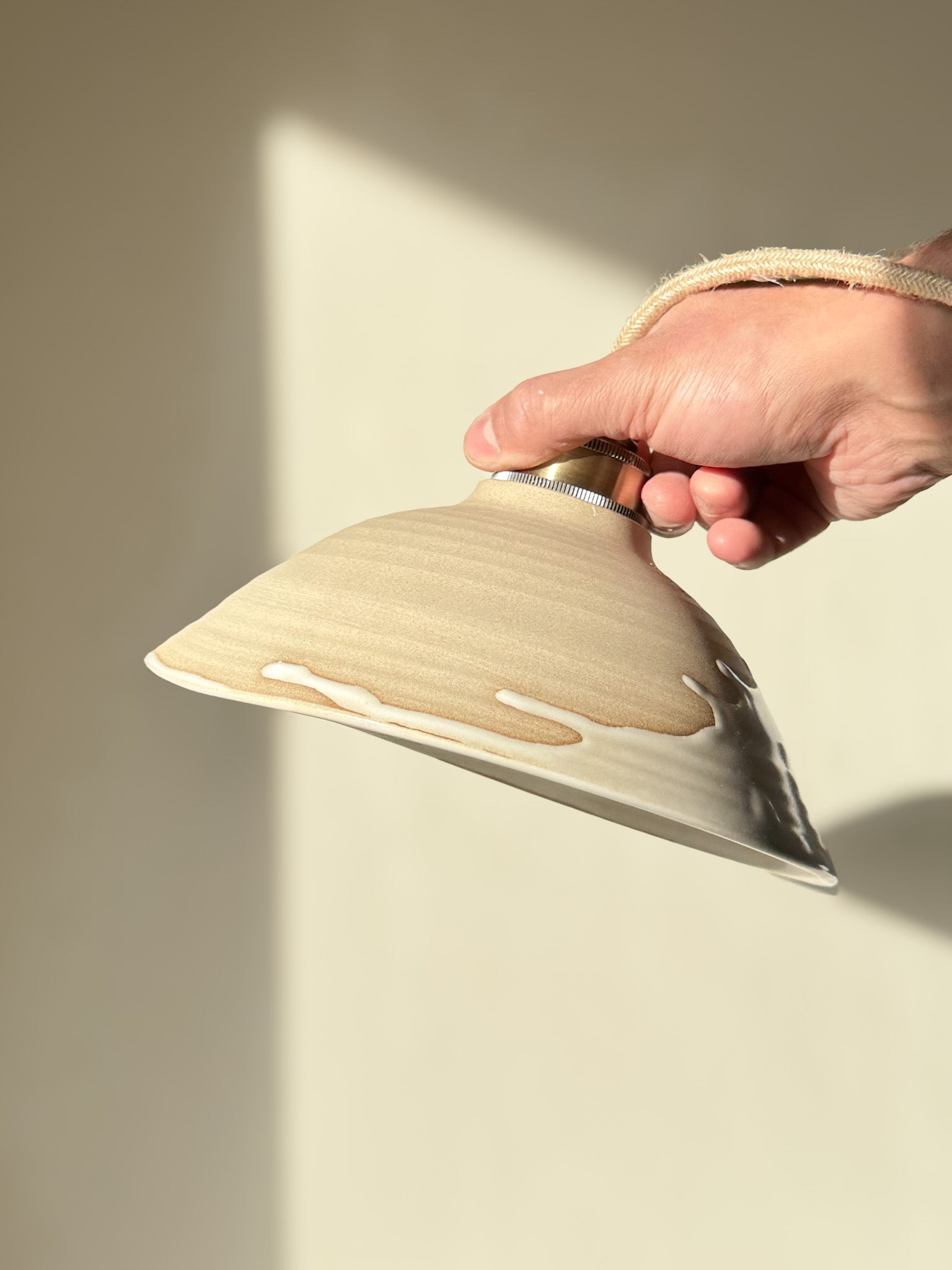 Hand holding Ceramic Lamp Shade – Yuki #02 with glossy white glaze and warm raw clay finish, showcasing a soft, elegant design.