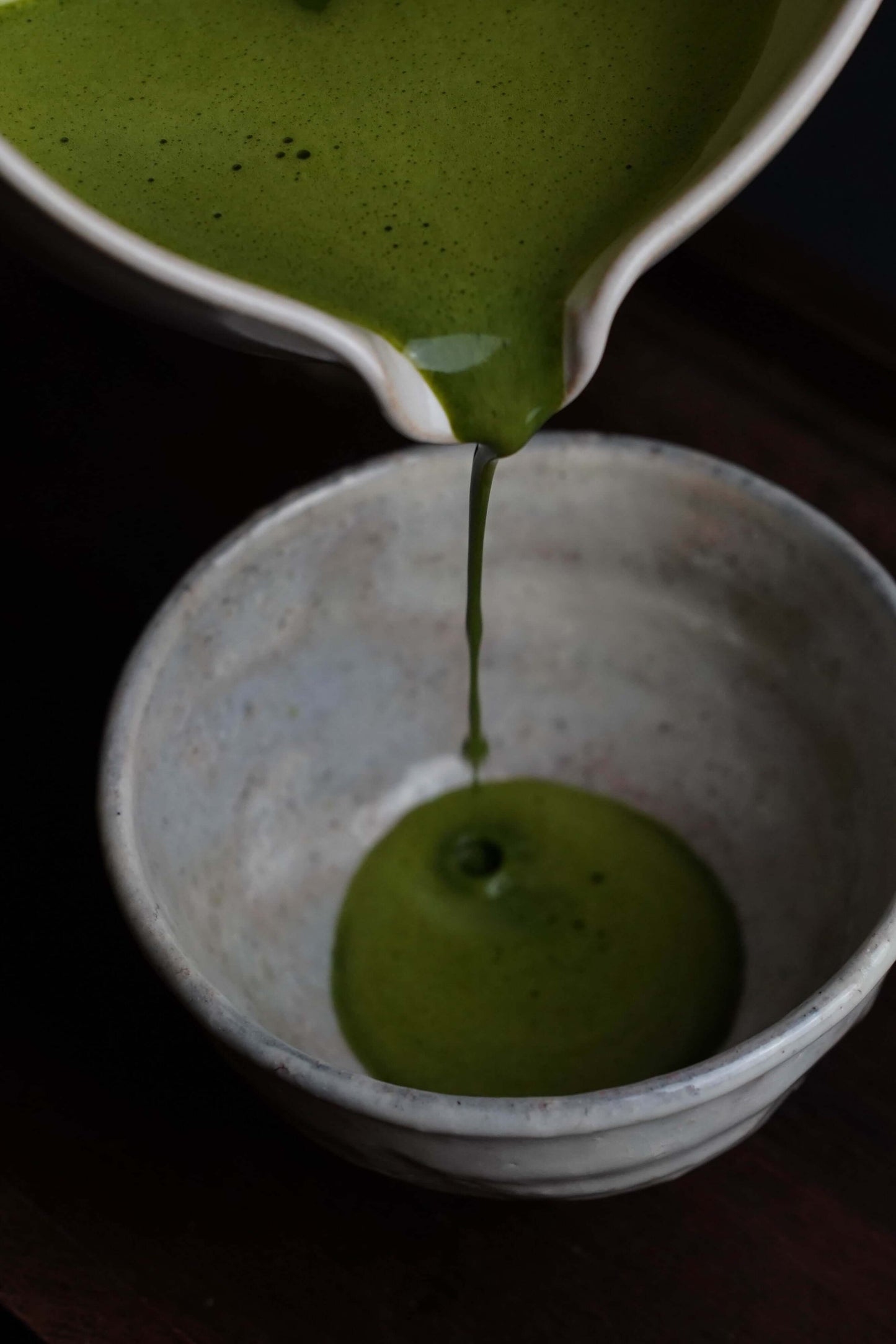 Pouring Fuji Matcha – Japan (Ceremonial Grade) into a traditional ceramic bowl, showcasing its vibrant green color and creamy texture.