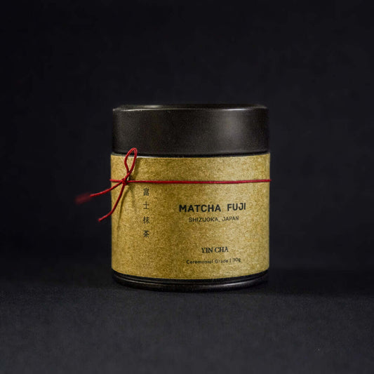 Ceremonial Matcha Powder in gold tin packaging by IKKAI Ceramics on dark background