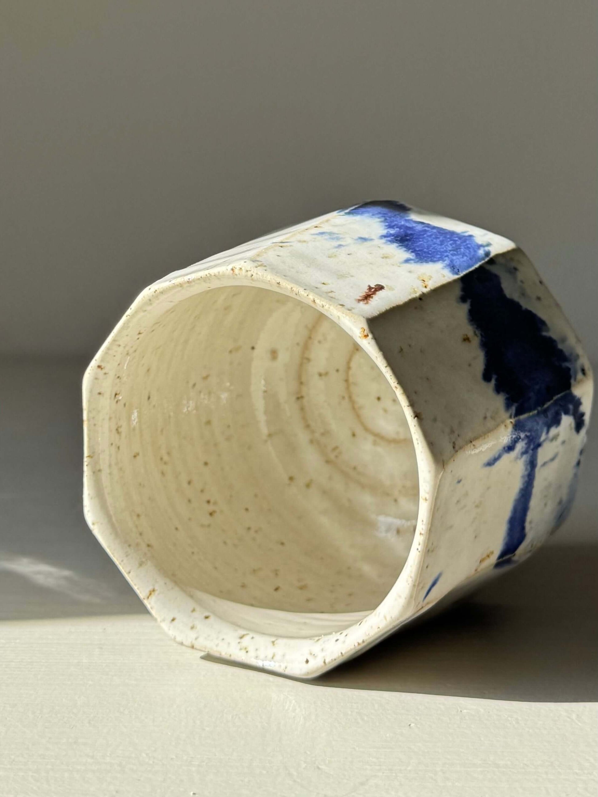 Handmade ceramic Faceted Cup – Cobalt Blue & Glossy White #01 with unique angles and blue glaze splashes.