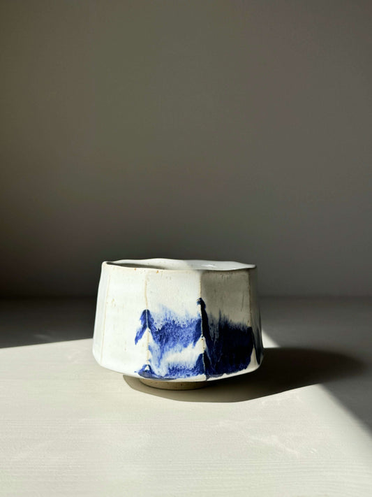 Faceted Matcha Bowl with glossy white glaze and cobalt blue splashes, highlighting modern design and texture.