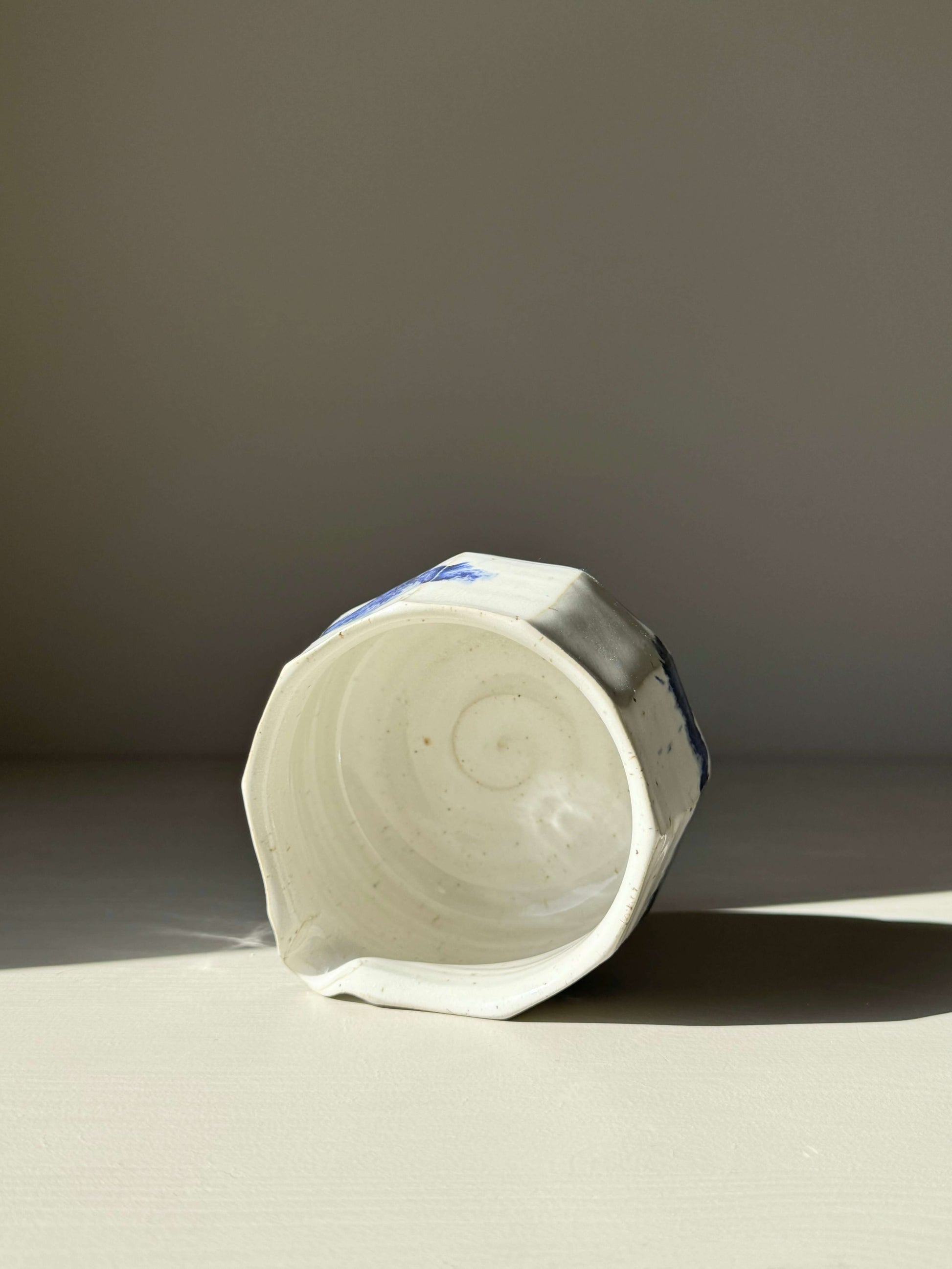 Faceted Matcha Bowl with spout in cobalt blue accents and glossy white glaze, showcasing modern design and textured details.