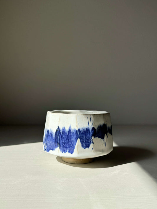 Faceted Matcha Bowl with cobalt blue splashes and glossy white glaze, featuring a unique modern design, perfect for tea ceremonies.