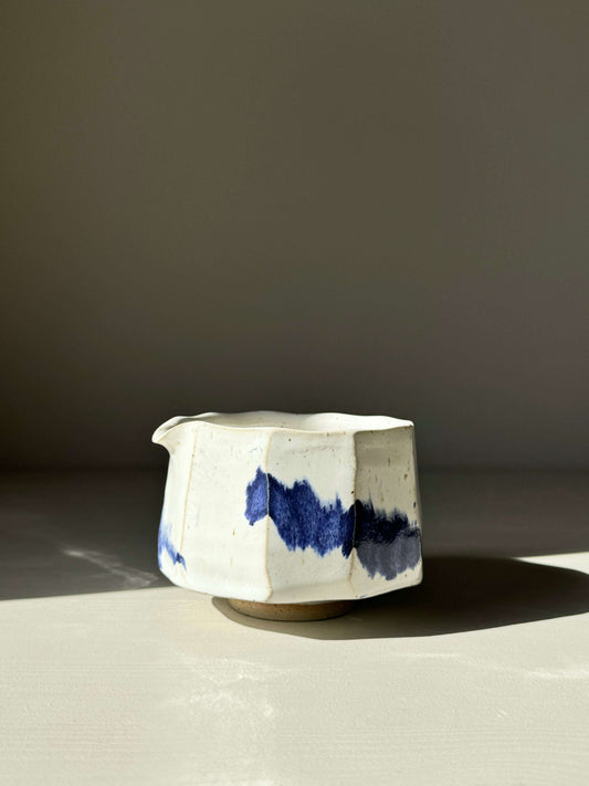 Faceted matcha bowl with spout, glossy white glaze, cobalt blue accents, modern design