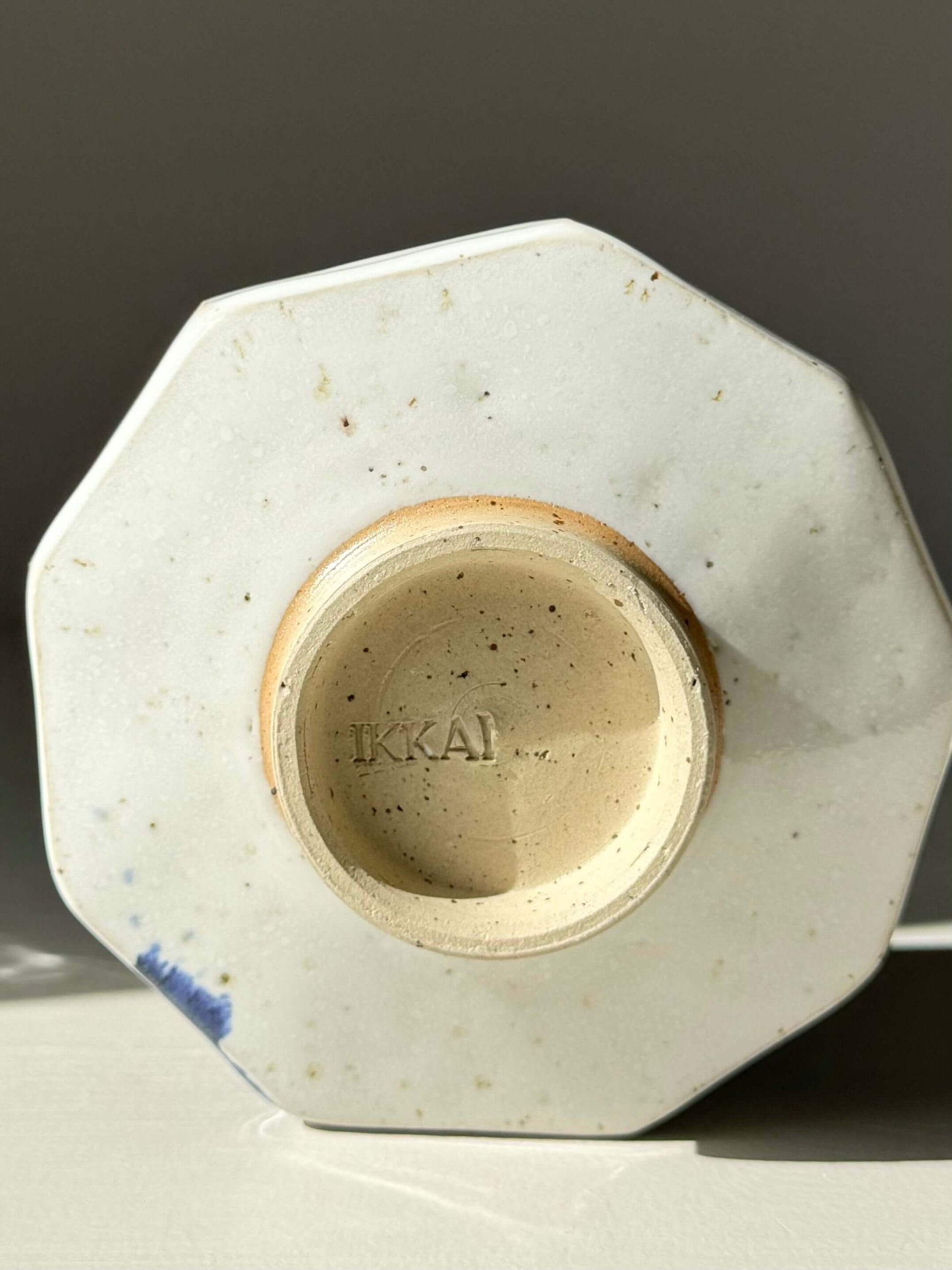 Base view of Faceted Matcha Bowl with cobalt blue accents, highlighting its glossy white glaze and unique design.