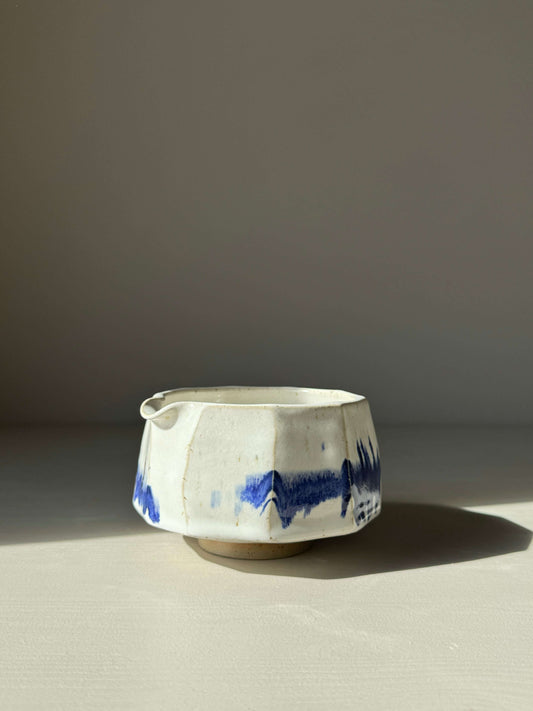 Faceted matcha bowl with spout, featuring glossy white glaze and cobalt blue accents, modern design.