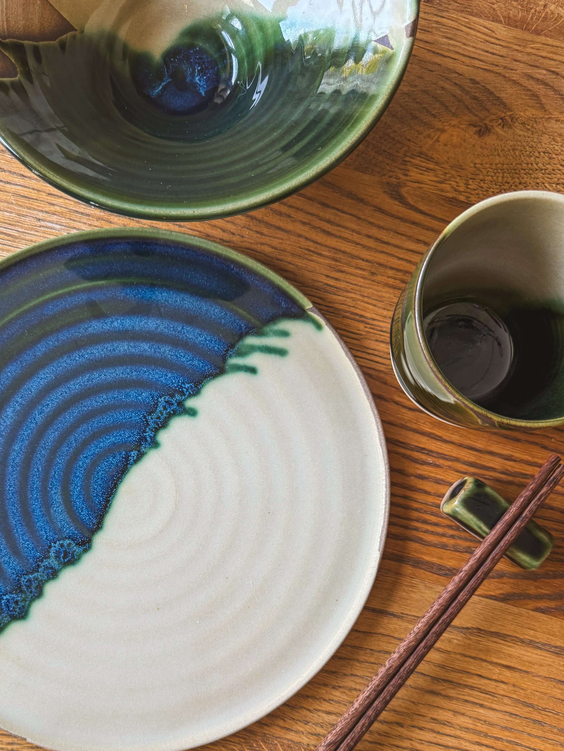 Flat Round Plate – Mori handmade ceramic with glossy green glaze and natural toffee clay finish on a wooden table.
