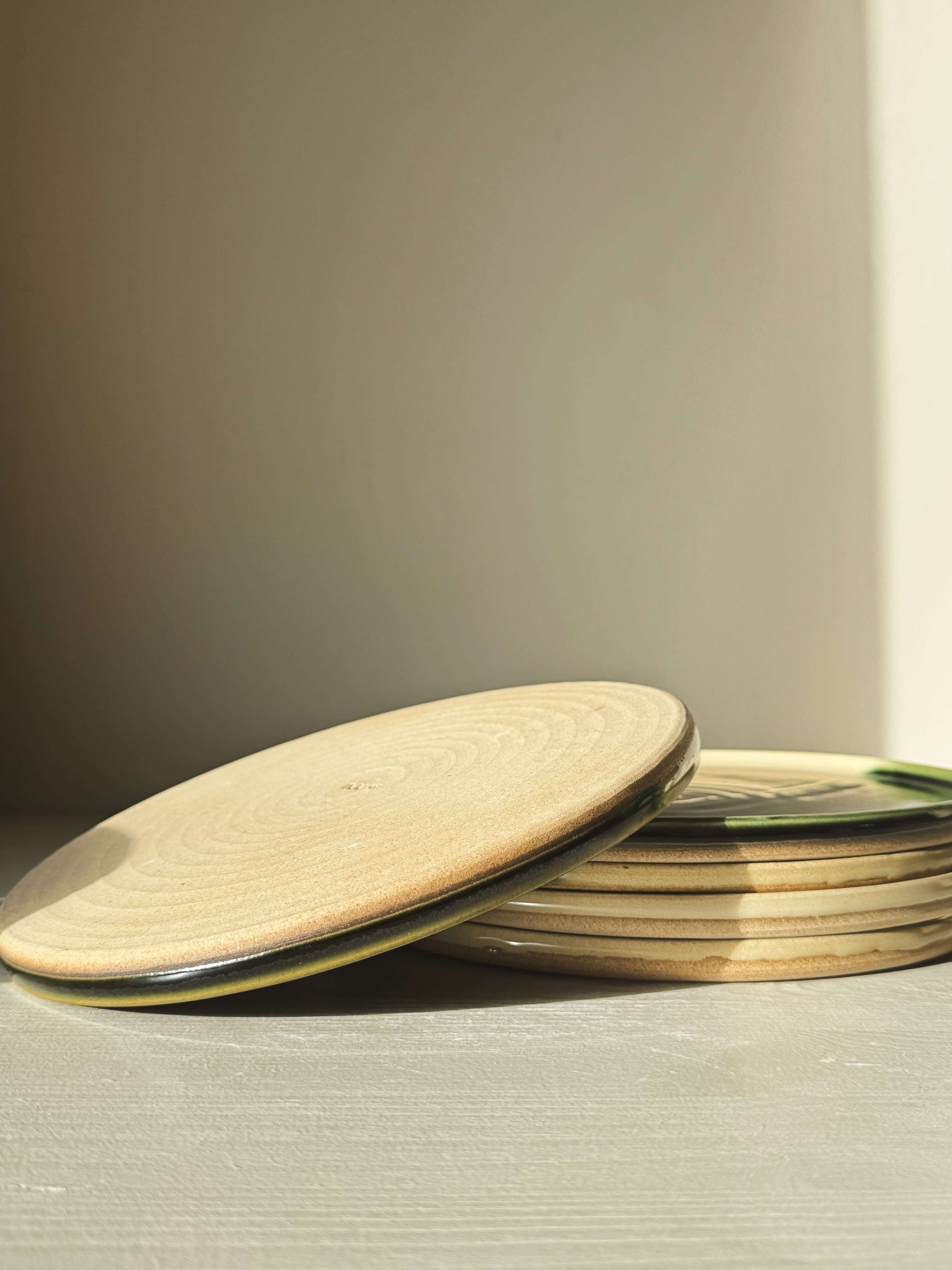 Flat Round Breakfast Plate – Mori series showcasing a stack of plates with natural toffee clay tones and glossy glaze finish.