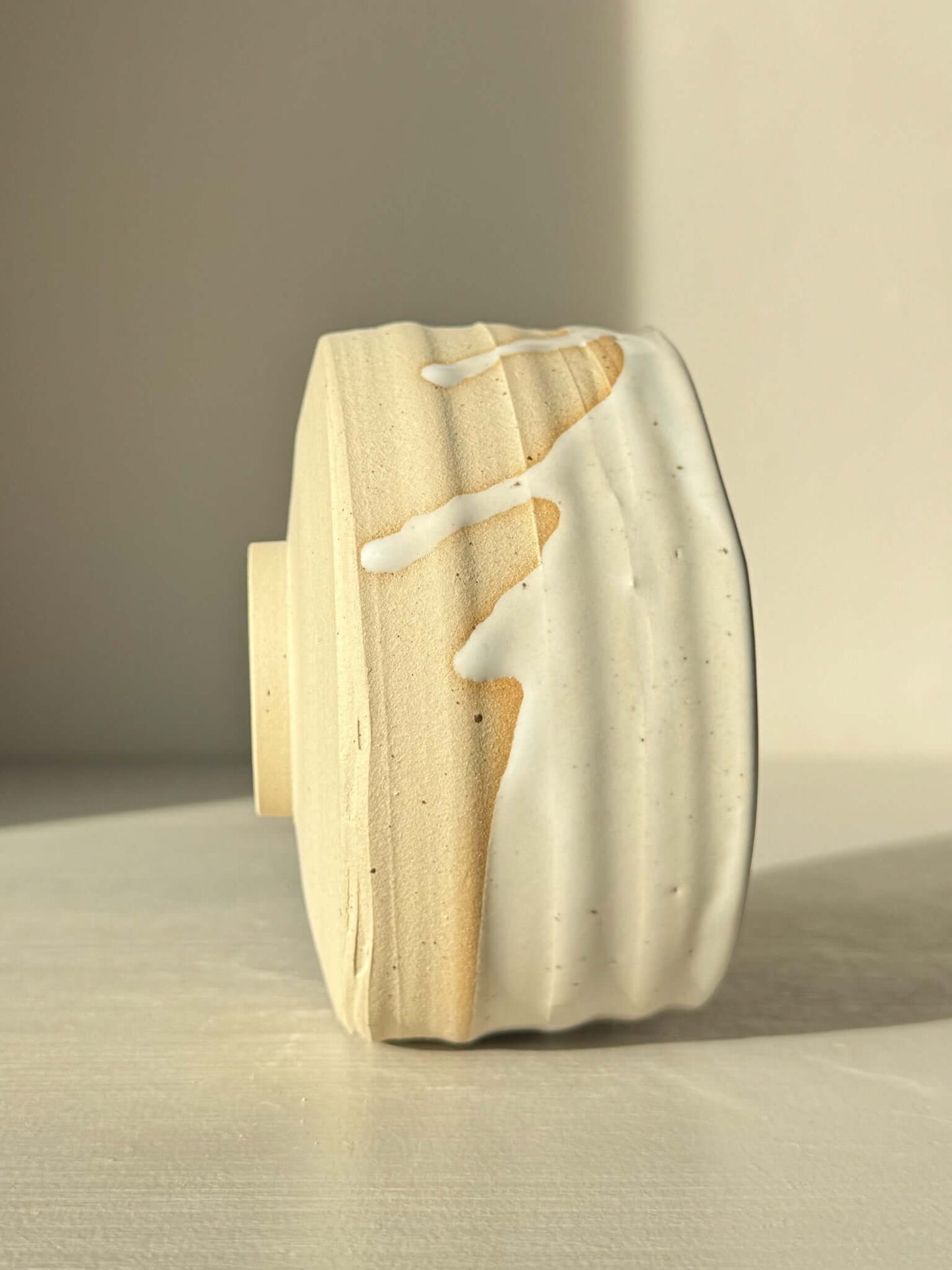 Side view of Matcha Bowl – Glossy White #05 with speckled stoneware clay and glossy white glaze showing natural drip pattern.