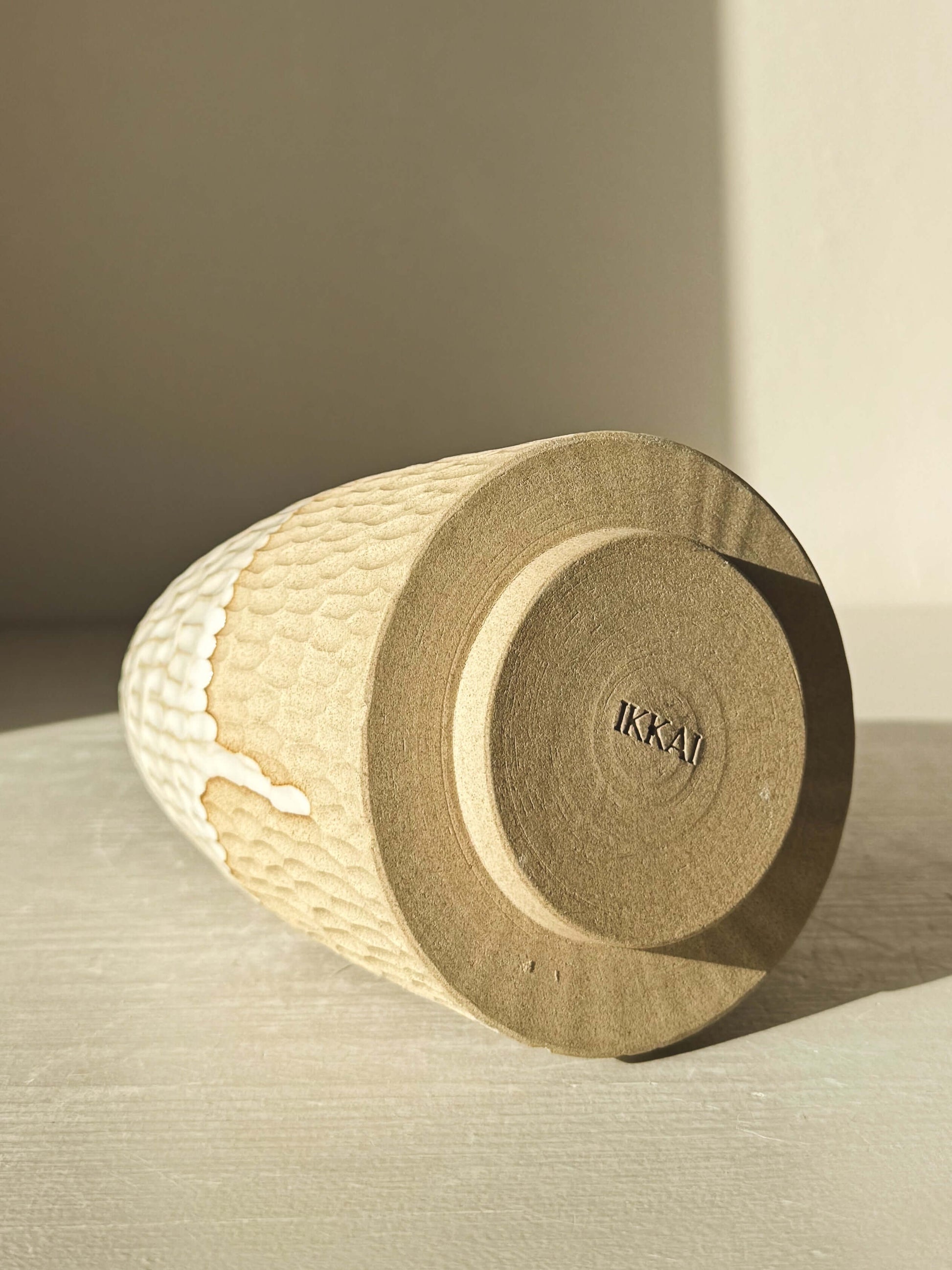 Carved Ceramic Tree – Yuki #03 showcasing hand-carved texture and glossy white glaze, lying on its side under sunlight.