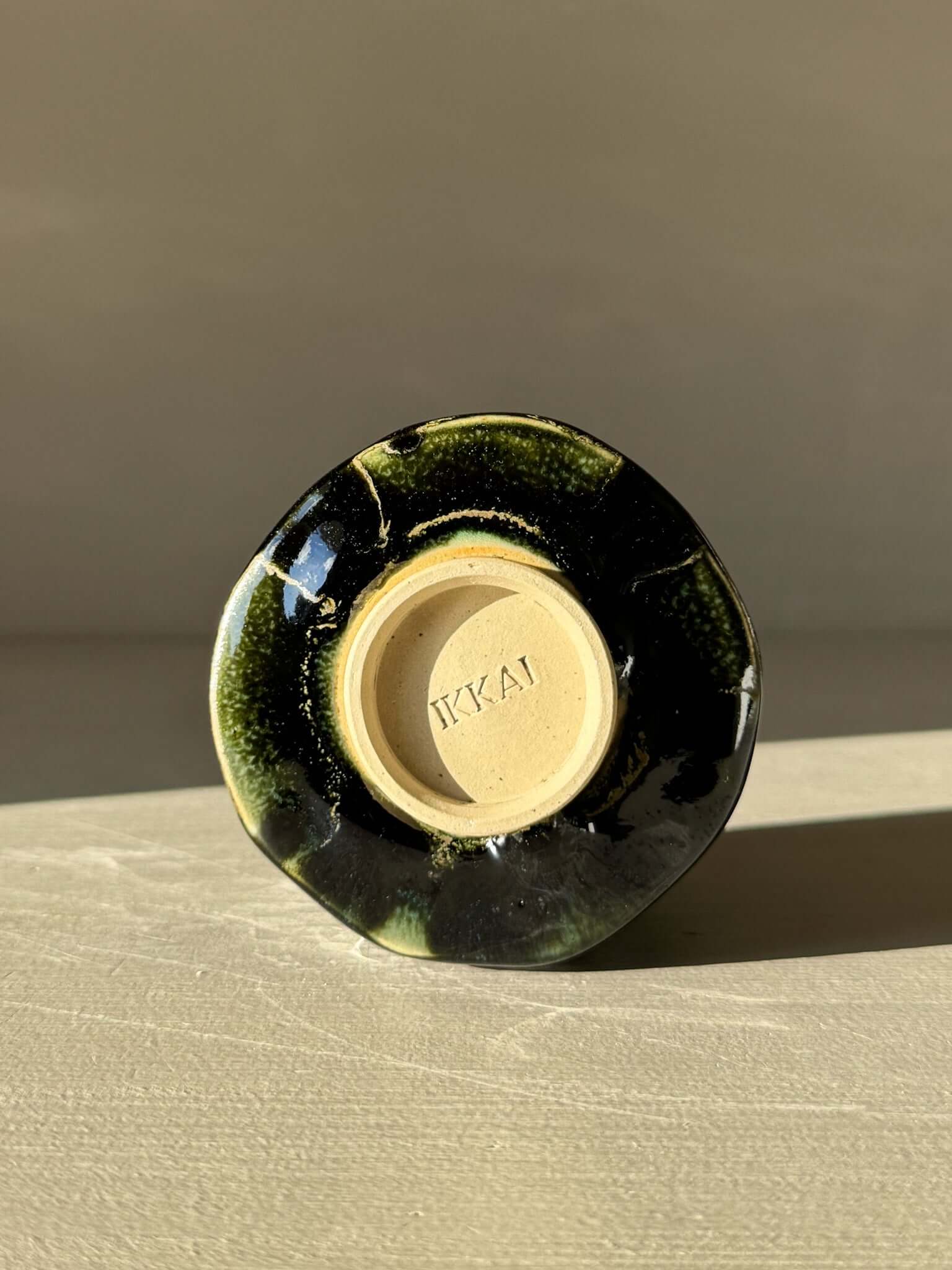 Base view of Yunomi Cup - Hinoki #15 showing deep green glaze and unique handmade texture.