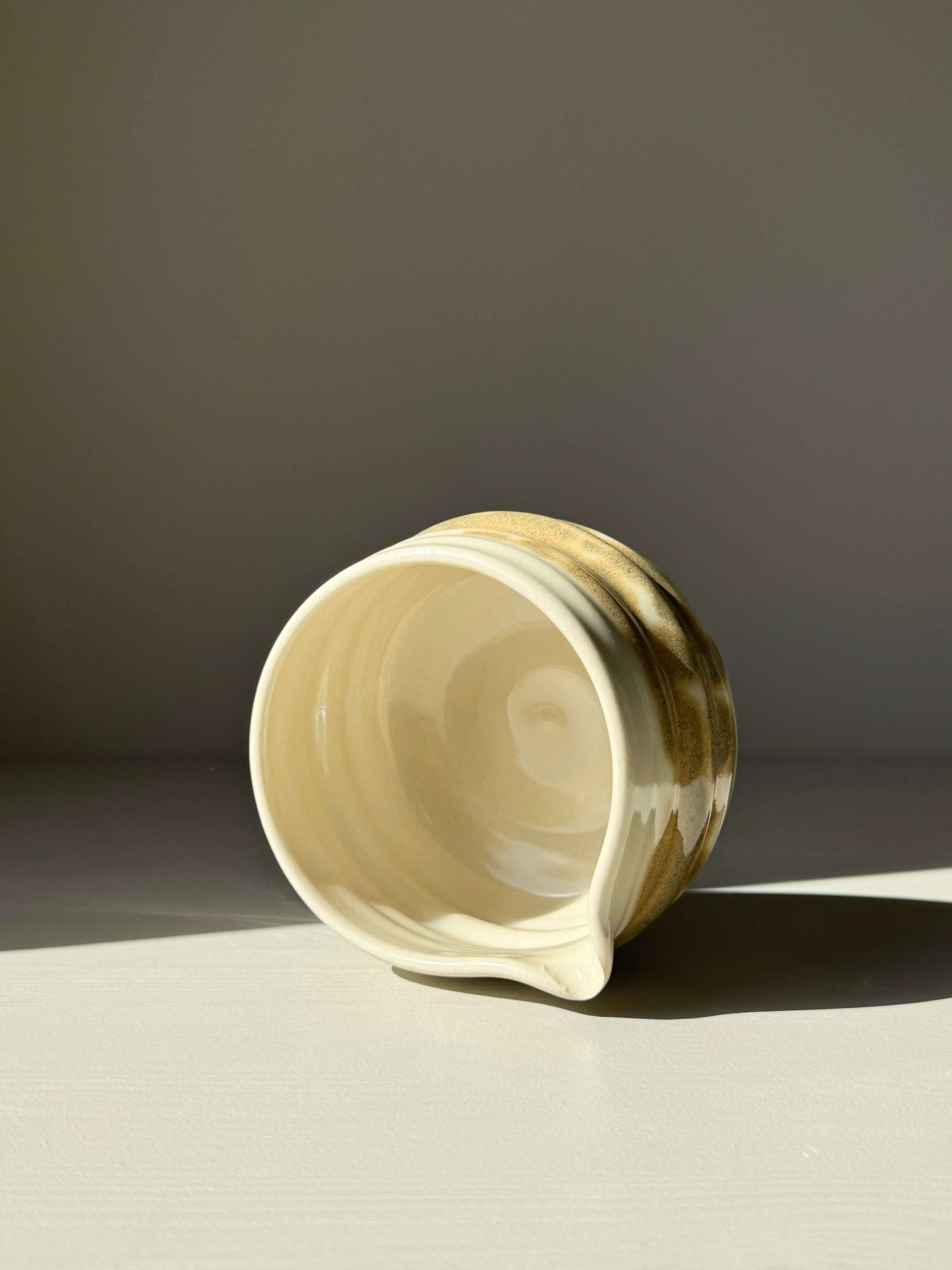 Hand-thrown matcha bowl with spout, clear glaze, tenmoku splashes in warm earthy tones, unique grooves, artisanal design
