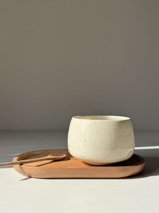 Cups - Speckled Clear Glaze handmade ceramic, soft rounded cup on wooden tray, sunlight highlighting freckled surface, approx. 6.5 cm high.