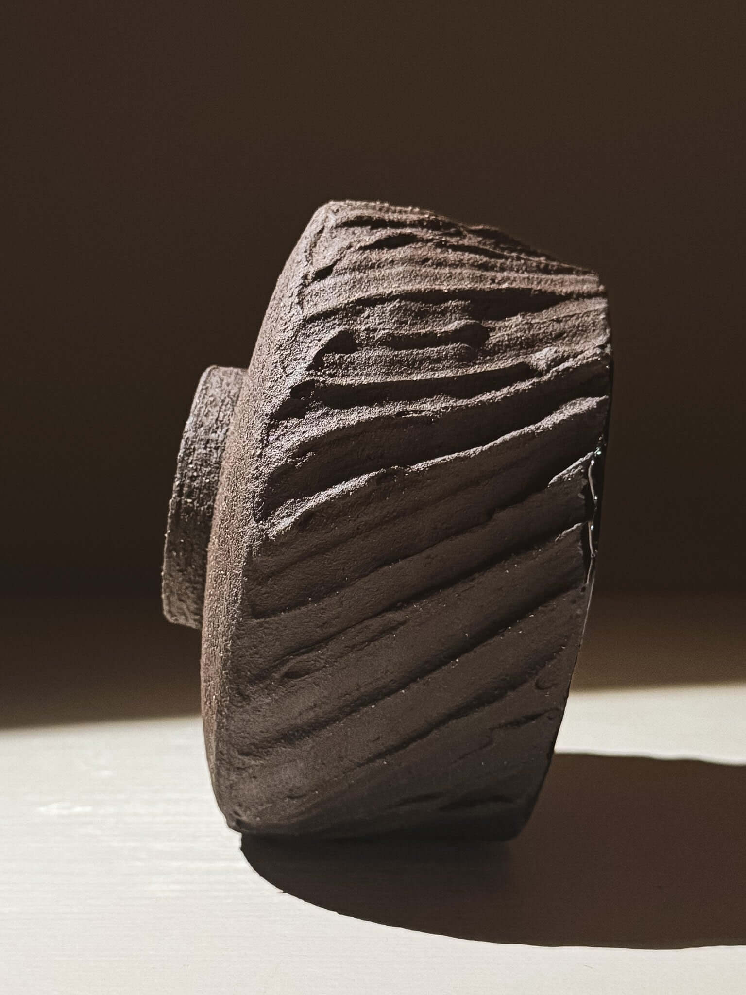 Side view of Kuro Matcha Bowl #01 showcasing textured dark brown exterior inspired by volcanic stone and earthy tones.