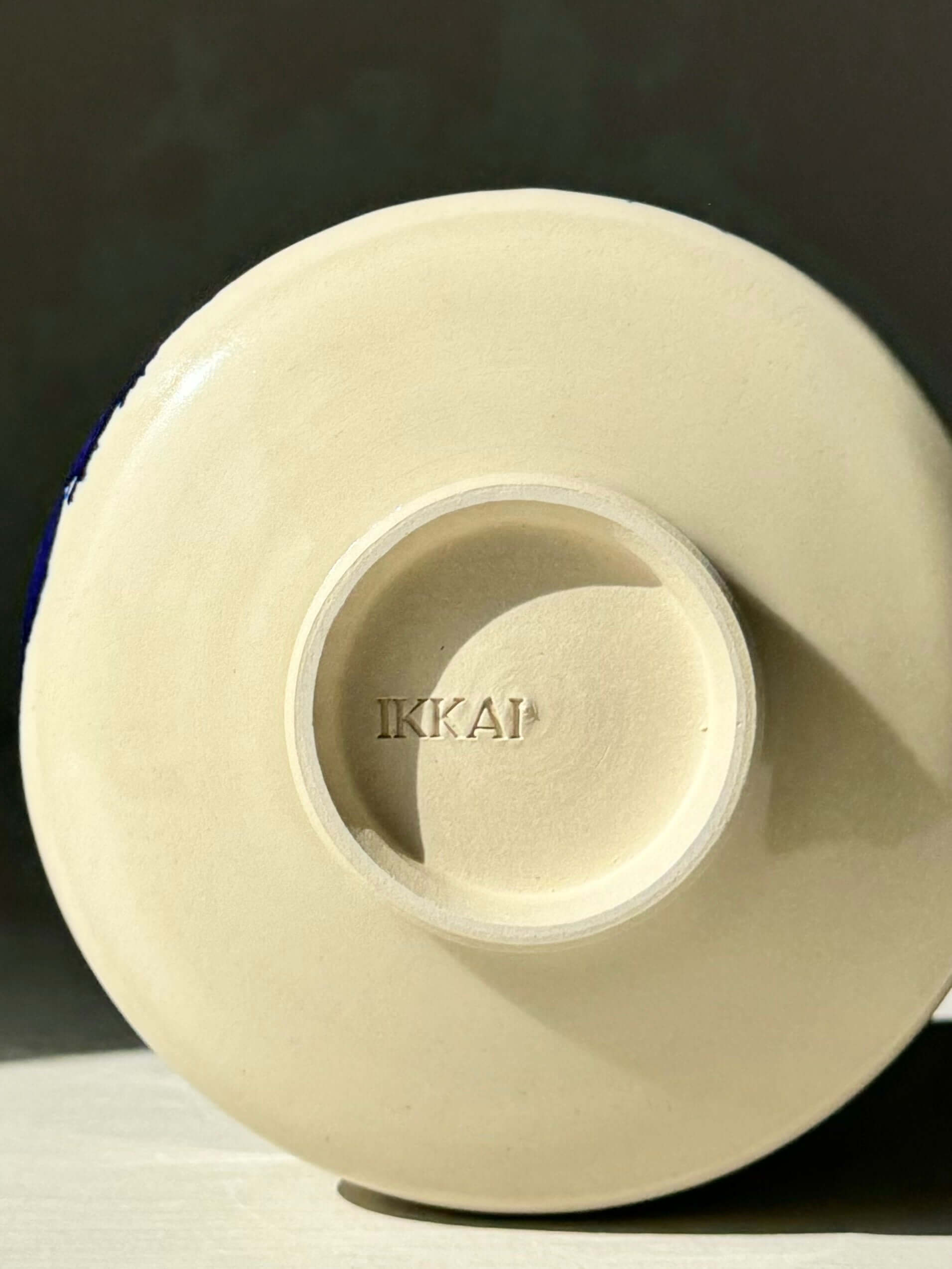 Base of handmade ceramic Matcha Bowl with Spout – Gosu, showing the artist's stamp IKKAÏ, part of the Gosu Series.