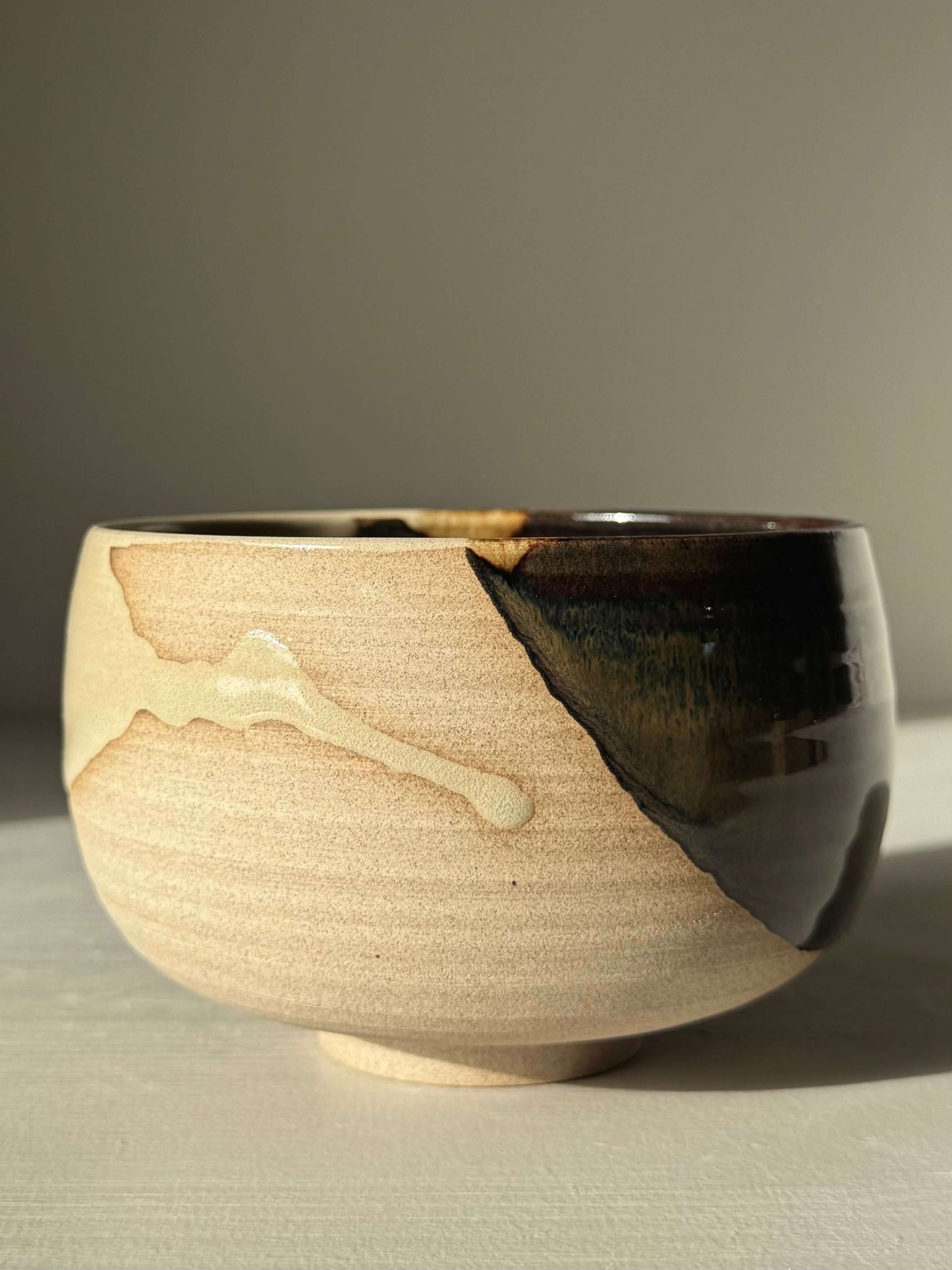 Handmade ceramic Matcha Bowl – Inyo #02 with dark tenmoku and clear glazes on stoneware, rounded design.