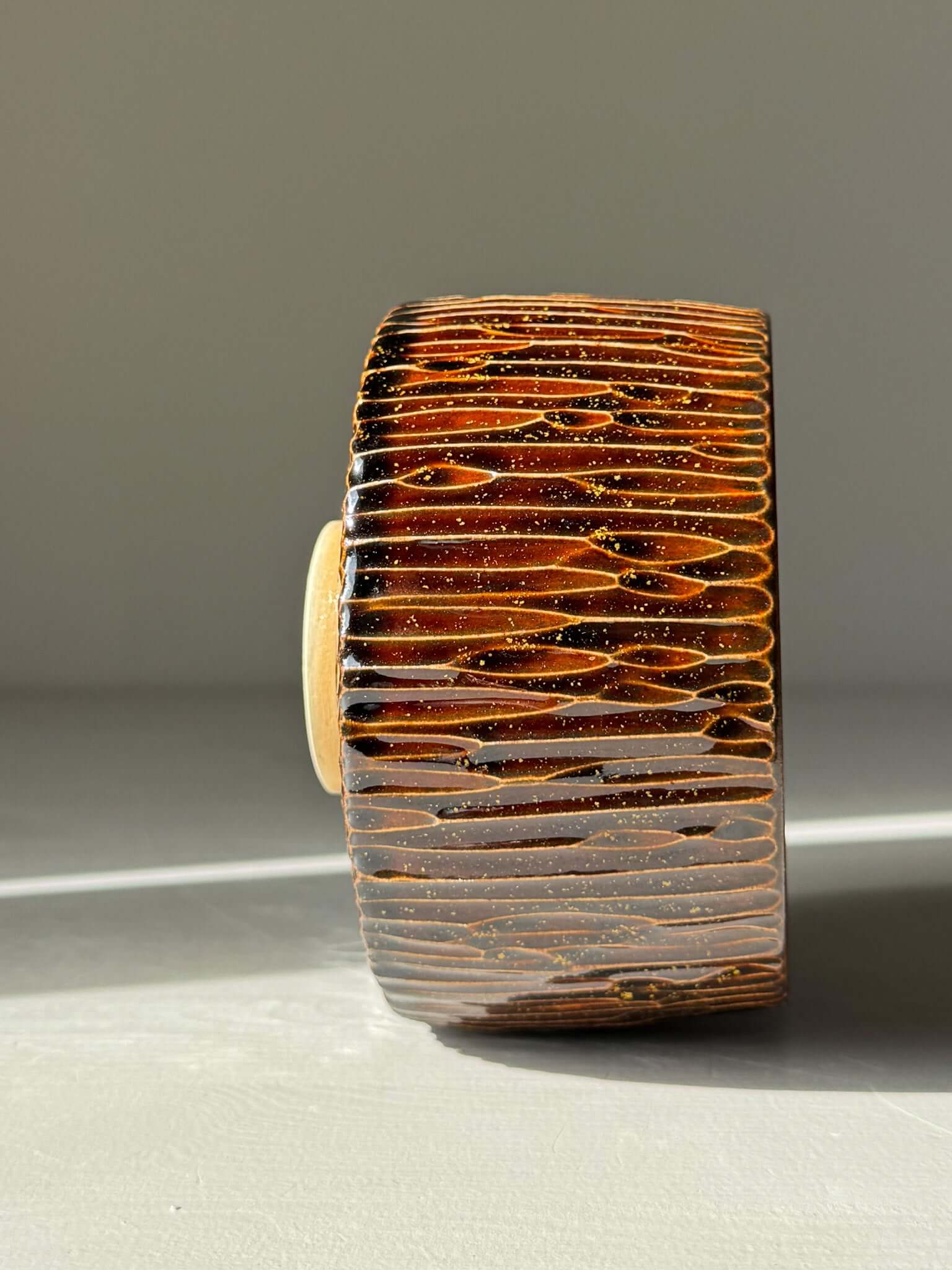 Matcha Bowl – Kinsei #02 handmade ceramic with glossy brown glaze, textured design, showcasing spiral gold and orange interior.