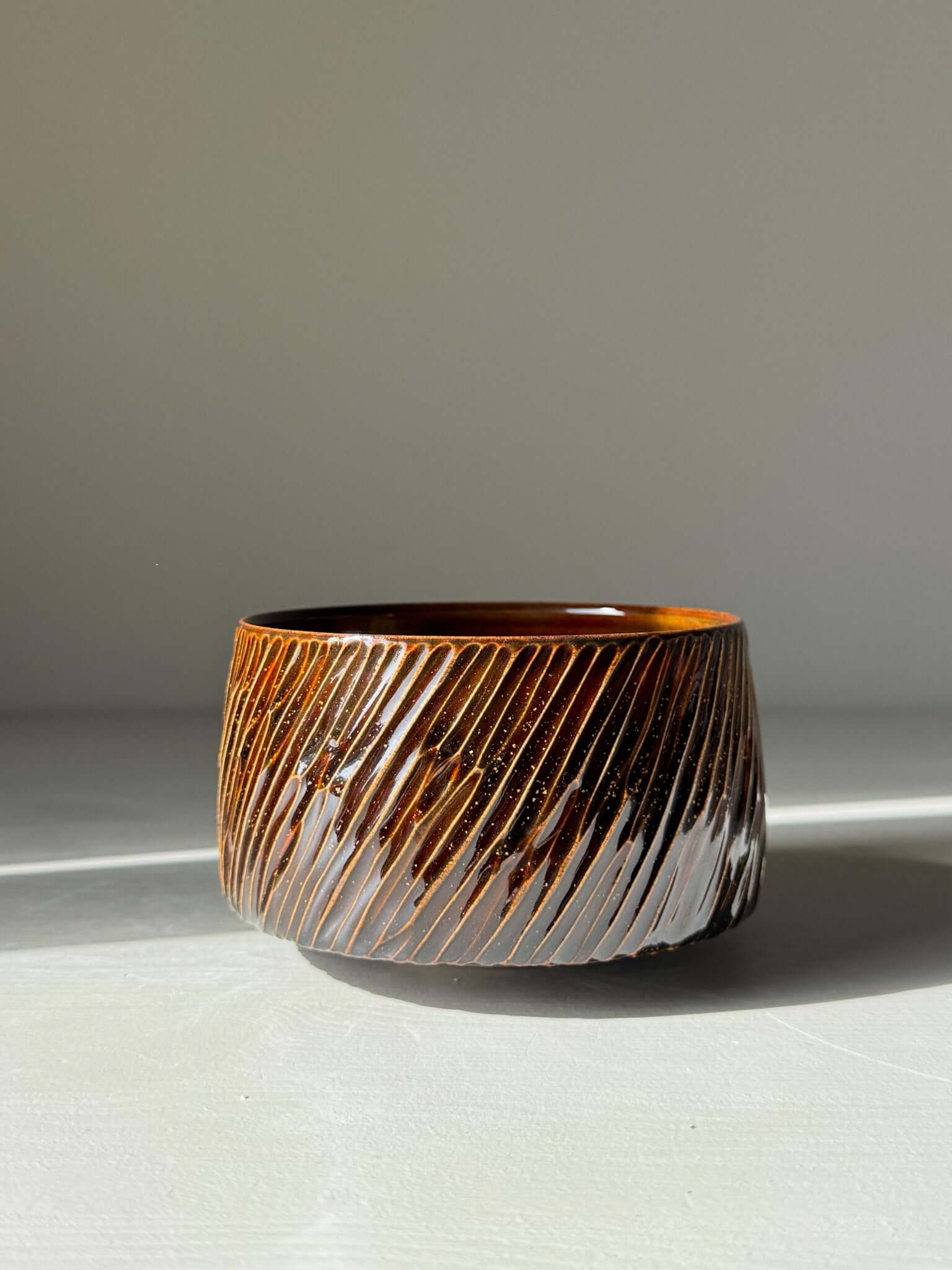 Handmade ceramic Matcha Bowl – Kinsei #04 with glossy brown exterior and golden-orange interior, 7cm x 11cm, unique and luminous.
