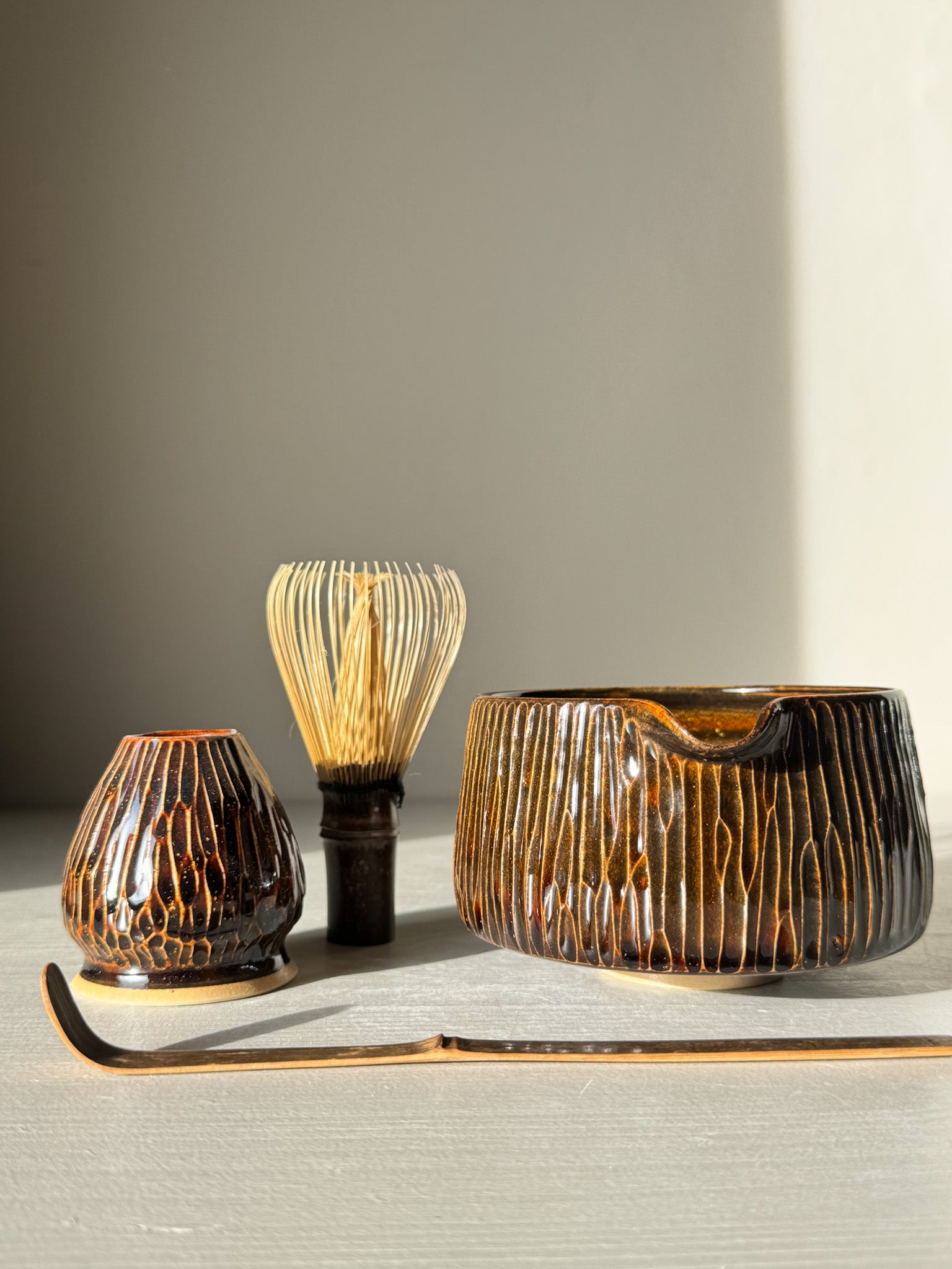 Matcha Bowl Spout – Kinsei #03 with handcrafted design, featuring golden and brown vertical lines, alongside traditional matcha accessories.