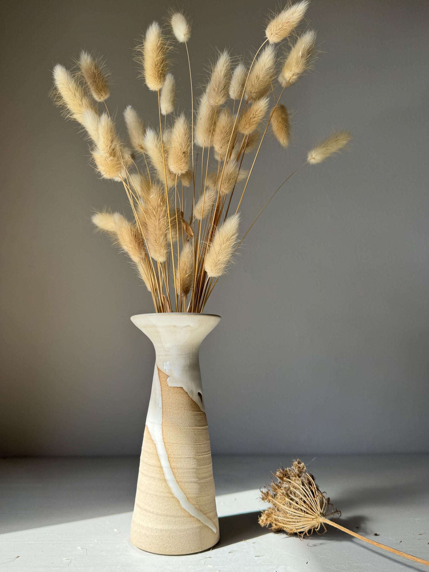 Medium Vase – Yuki #02 handmade ceramic with dried grasses, showcasing graceful white glaze flow on warm stoneware surface.