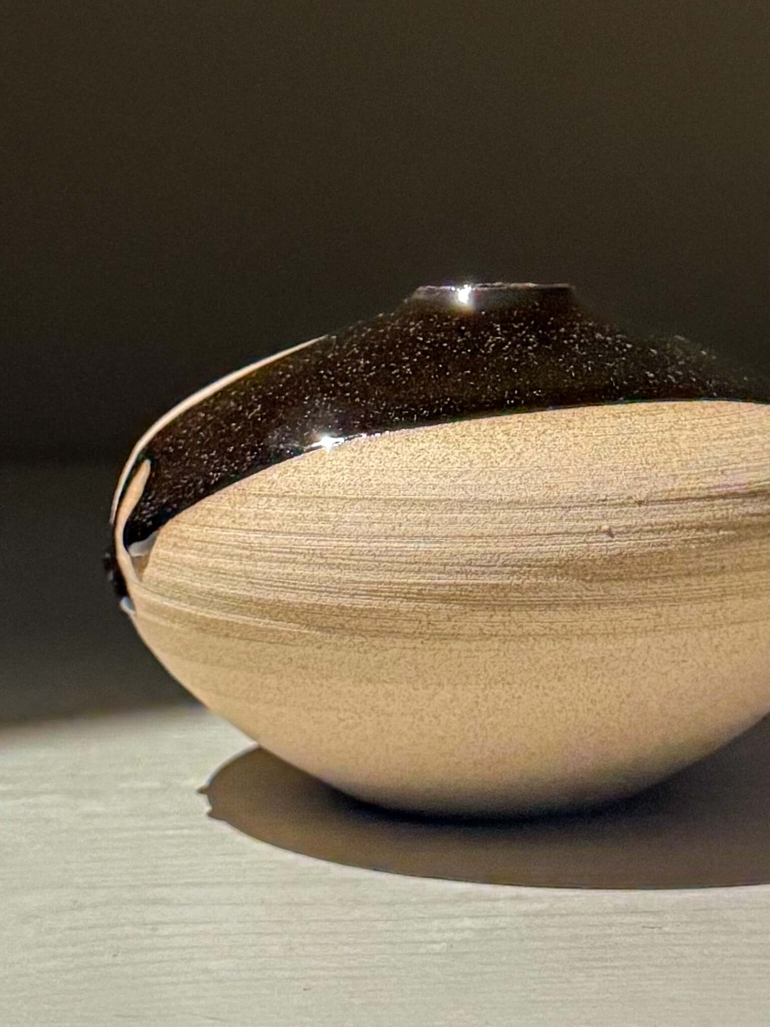 Orb Vase – Kuro #04, a unique japanese handmade ceramic orb vase with a smooth rounded shape and organic glaze patterns.