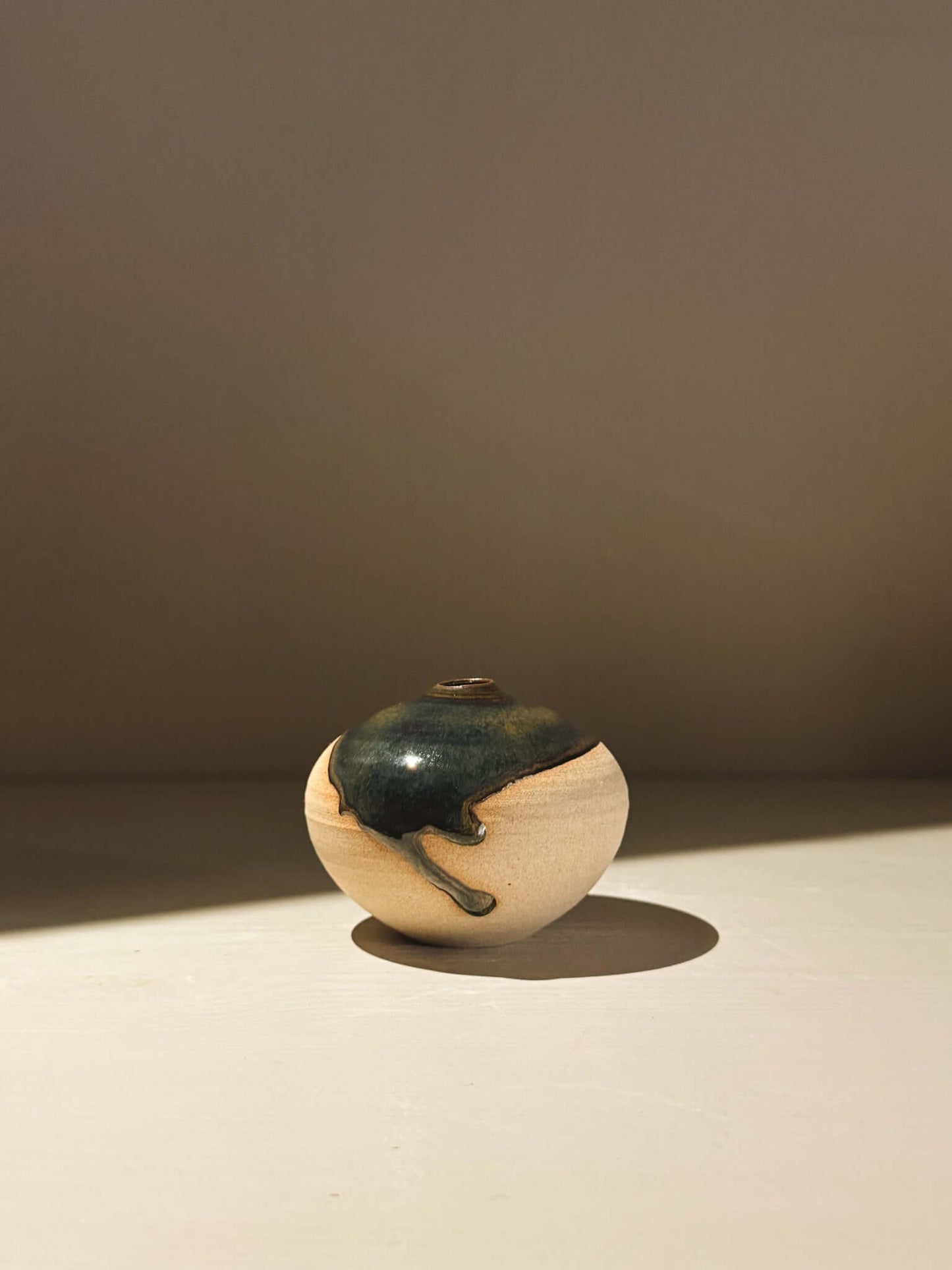 Orb Vase – Tenmoku #14 handmade ceramics with unique glaze patterns on a soft spherical form.