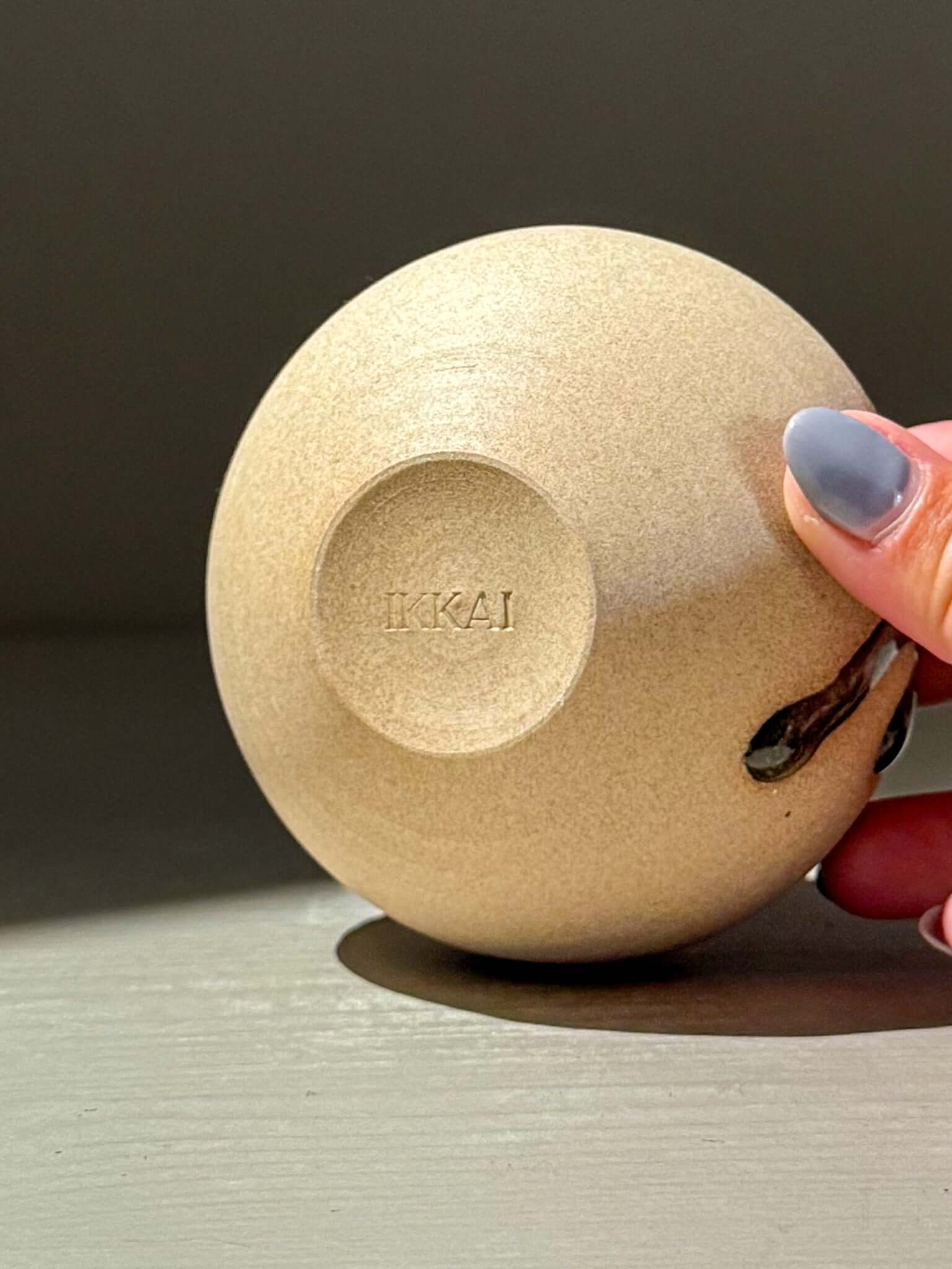 Handmade ceramics - Orb Vase – Tenmoku #14, showcasing the smooth bottom with 'IKKAI' imprint.